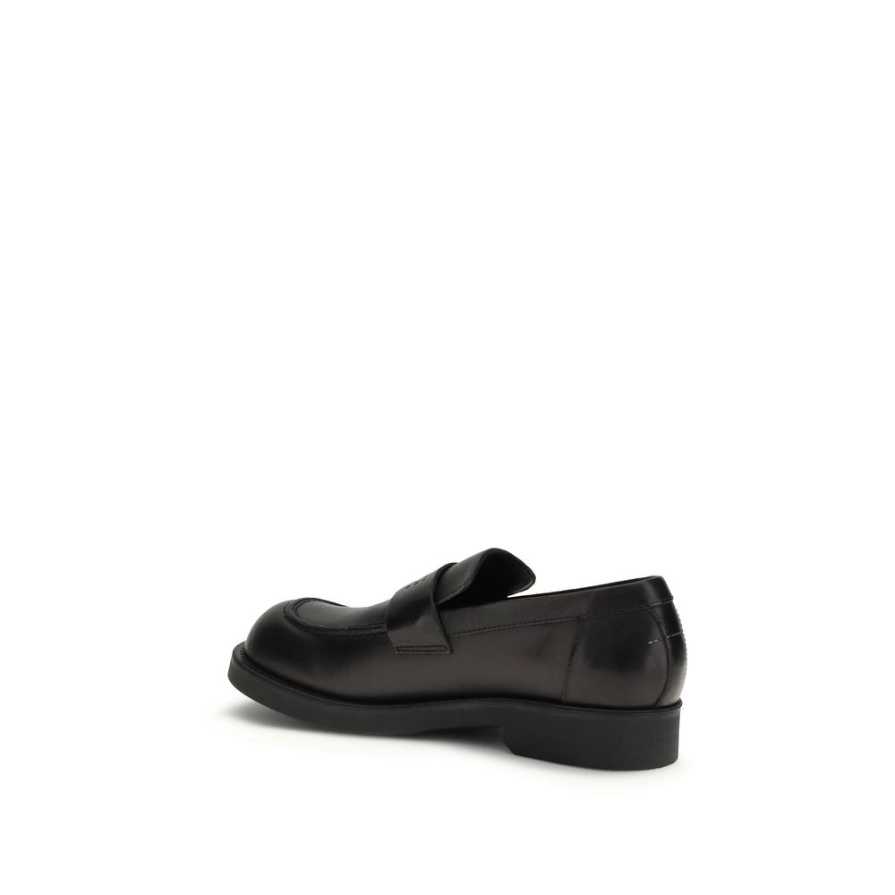 Indulge in the opulence of MM6 Black Calf Leather Bos Taurus Slip-On Loafers, where exquisite craftsmanship meets timeless elegance for the discerning individual.