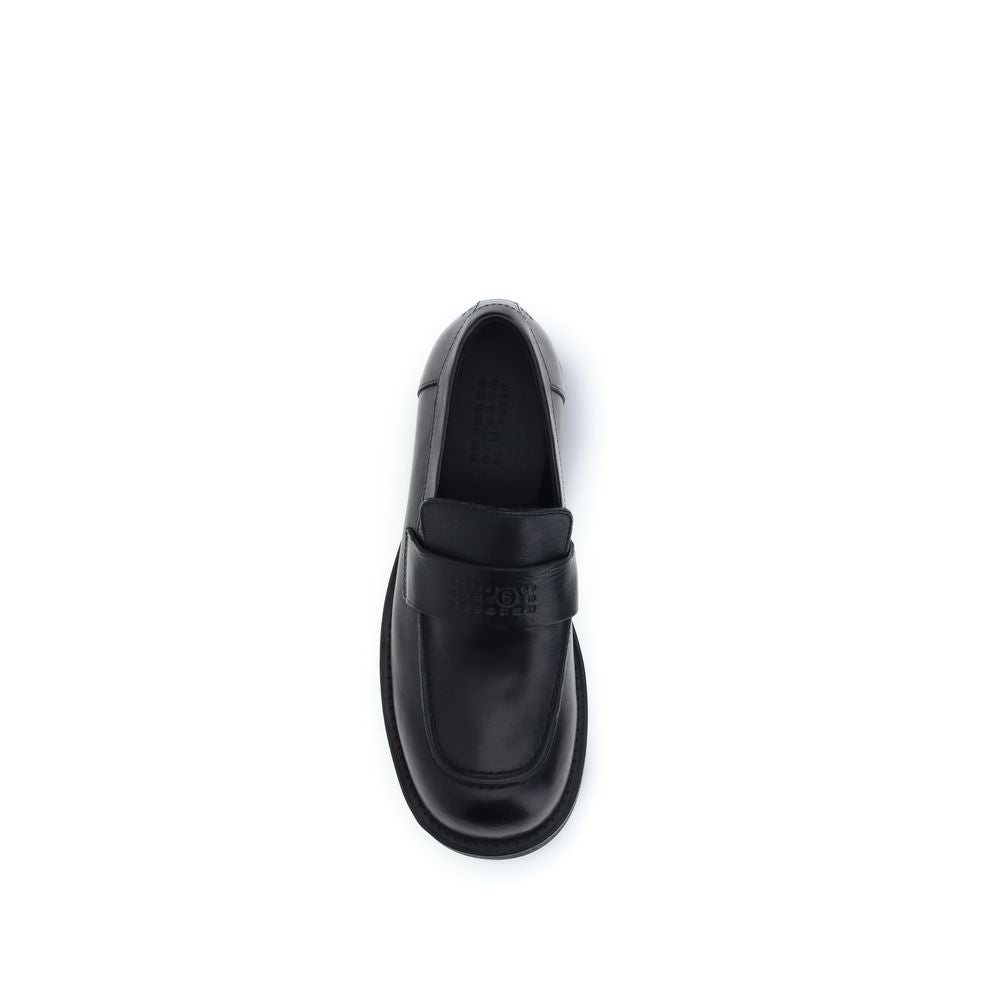 Elevate your elegance with MM6 Black Calf Leather Bos Taurus Slip-On Loafers, where sumptuous craftsmanship meets timeless sophistication for the discerning individual.