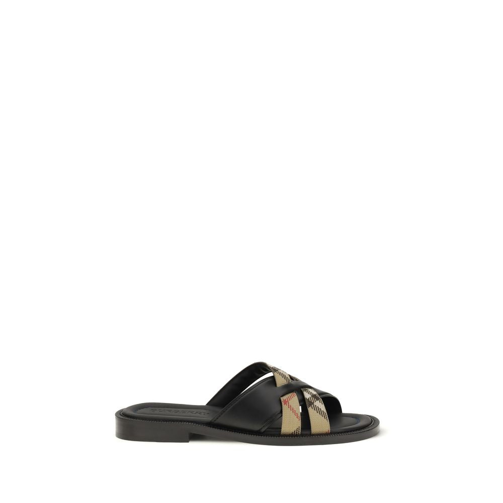 Indulge in the Burberry Black Calf Leather Bos Taurus Flat Sandals, where exquisite craftsmanship meets timeless elegance, perfect for the discerning connoisseur.