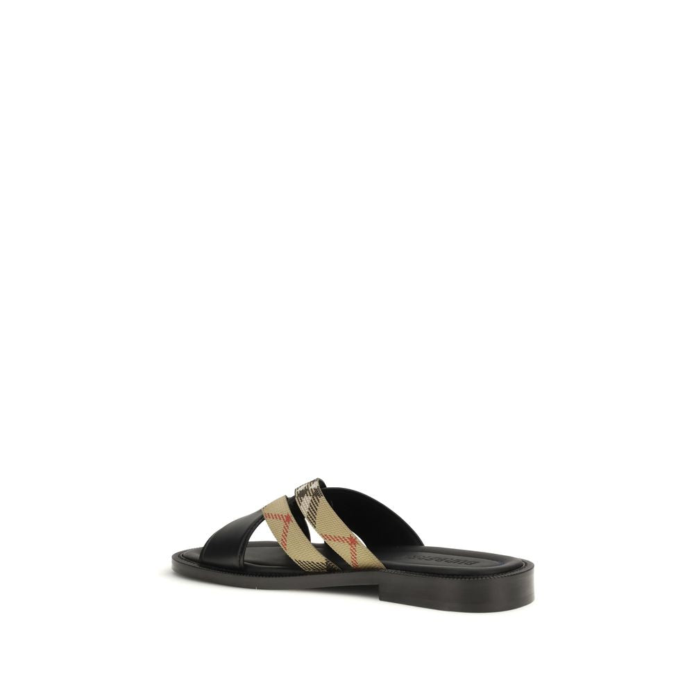 Indulge in the Burberry Black Calf Leather Bos Taurus Flat Sandals, where exquisite craftsmanship meets timeless elegance, perfect for the discerning connoisseur.