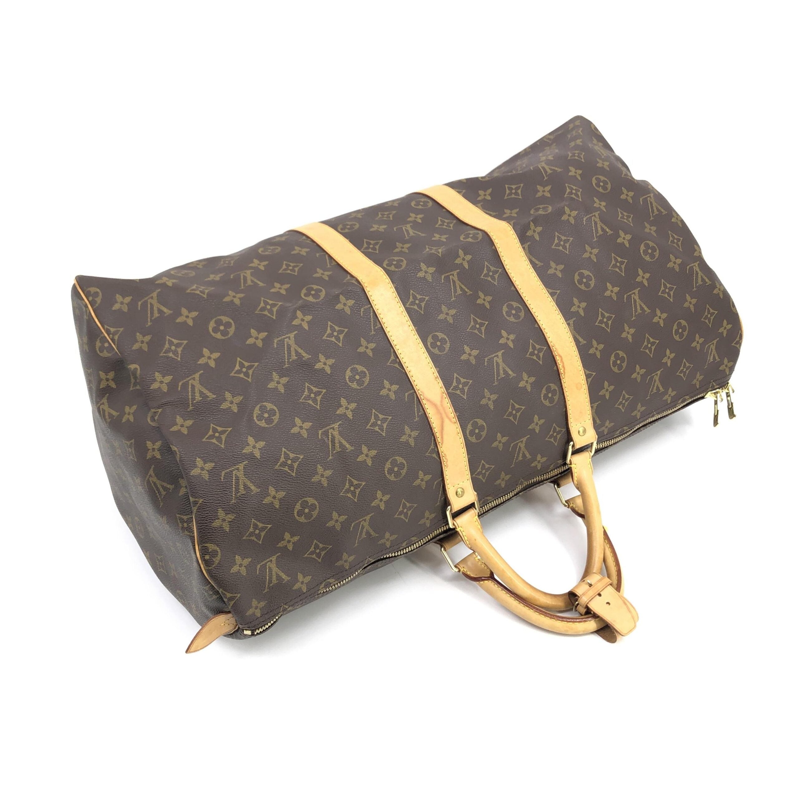 Indulge in the timeless elegance of the Louis Vuitton Monogram Keepall 55 Handbag, a masterpiece of exquisite craftsmanship and iconic design, perfect for discerning travelers.