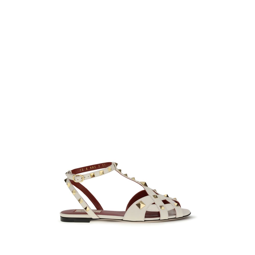 Experience the exquisite sophistication of Valentino Garavani's Beige Goatskin Flat Sandals, crafted with antique-effect brass studs for a timeless allure.