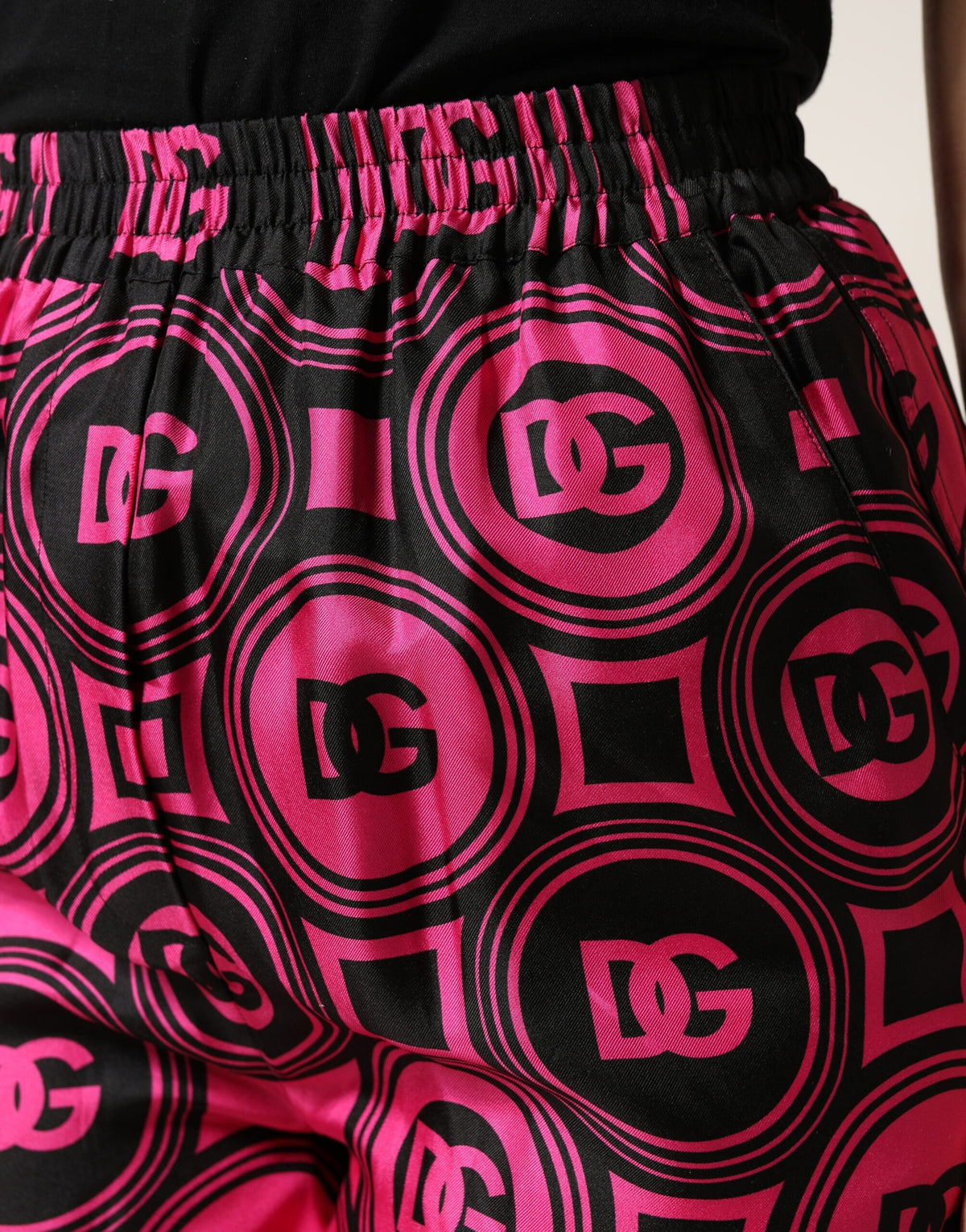 Indulge in the opulence of Dolce & Gabbana's Black Fuchsia Silk Logo Elastic Waist Shorts, where exquisite Italian craftsmanship meets effortless luxury for the discerning individual.