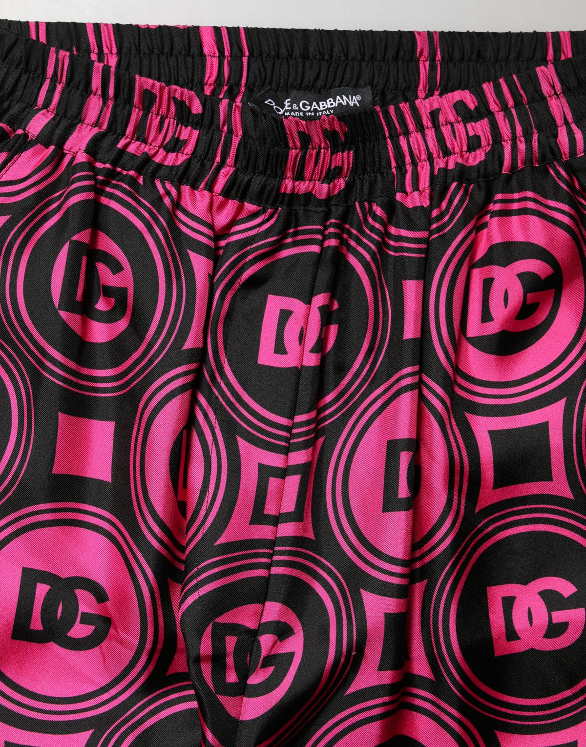 Indulge in the exquisite craftsmanship of Dolce & Gabbana's Black Fuchsia Silk Logo Elastic Waist Shorts, a luxurious statement piece for the discerning individual.