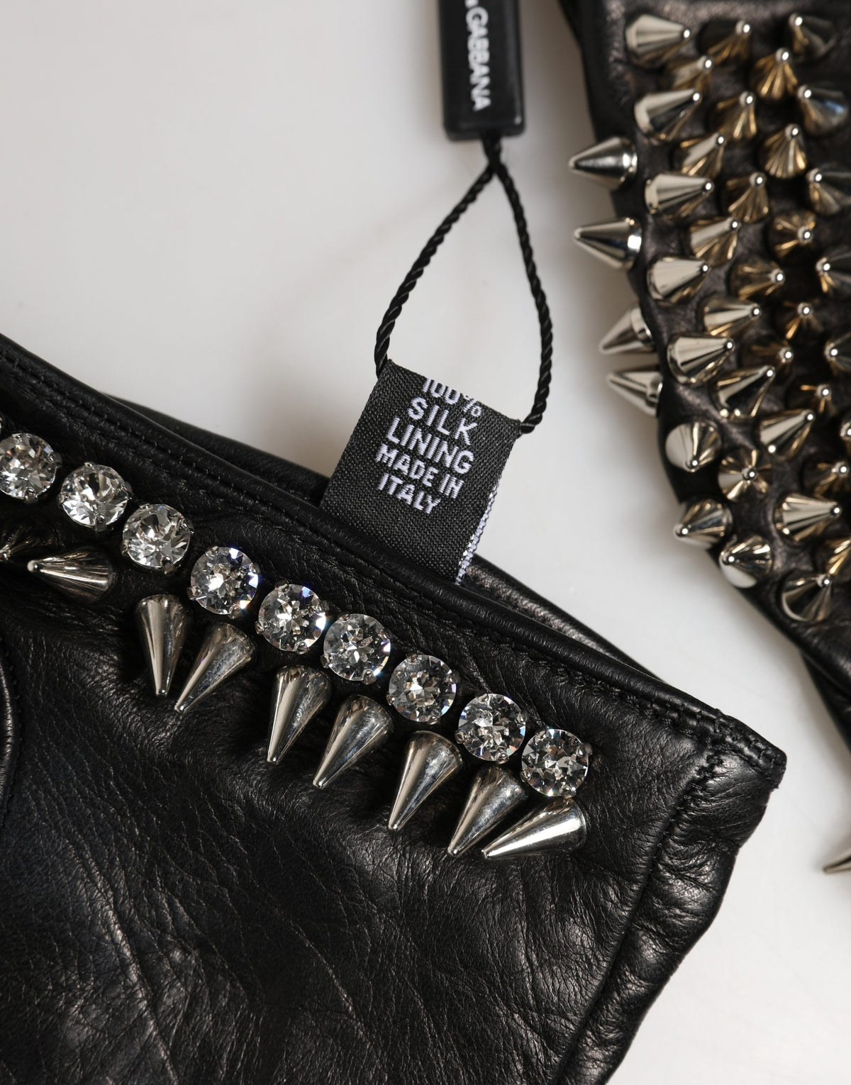 Indulge in the exquisite craftsmanship of Dolce & Gabbana's Black Embellished Leather Fingerless Gloves, a luxurious accessory that elevates your winter style with timeless elegance.