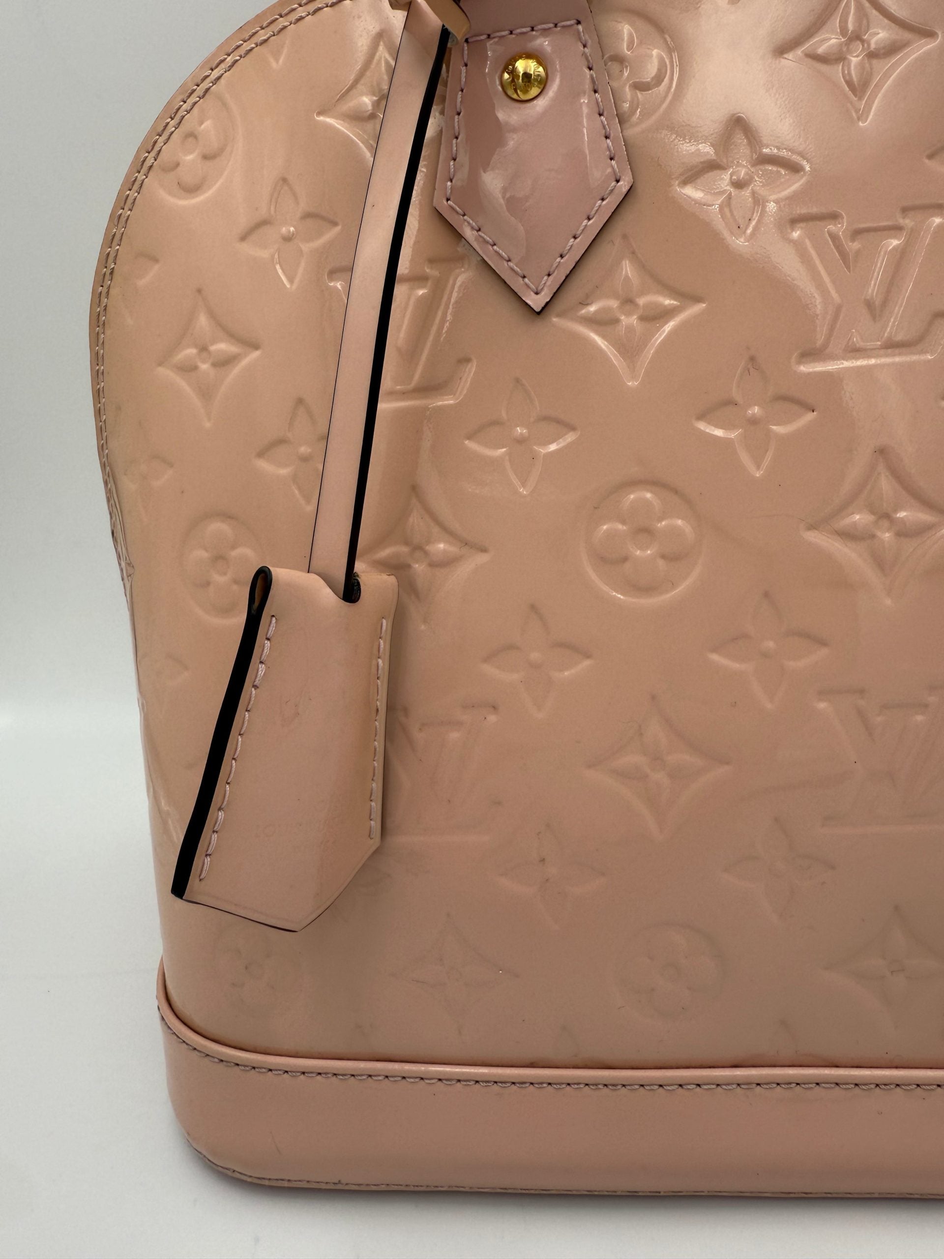 Indulge in the timeless elegance of the Louis Vuitton Alma MM Pink Patent Monogram Handbag, a masterpiece of exquisite craftsmanship and iconic style for discerning tastes.