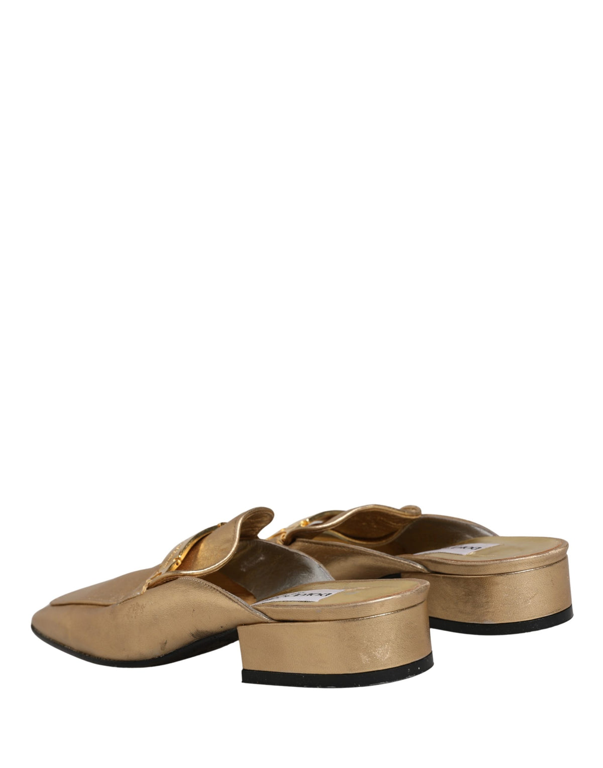 Step into a realm of opulence with Dolce & Gabbana's gold leather mule loafers, where Italian craftsmanship meets timeless elegance, perfect for any discerning fashionista.