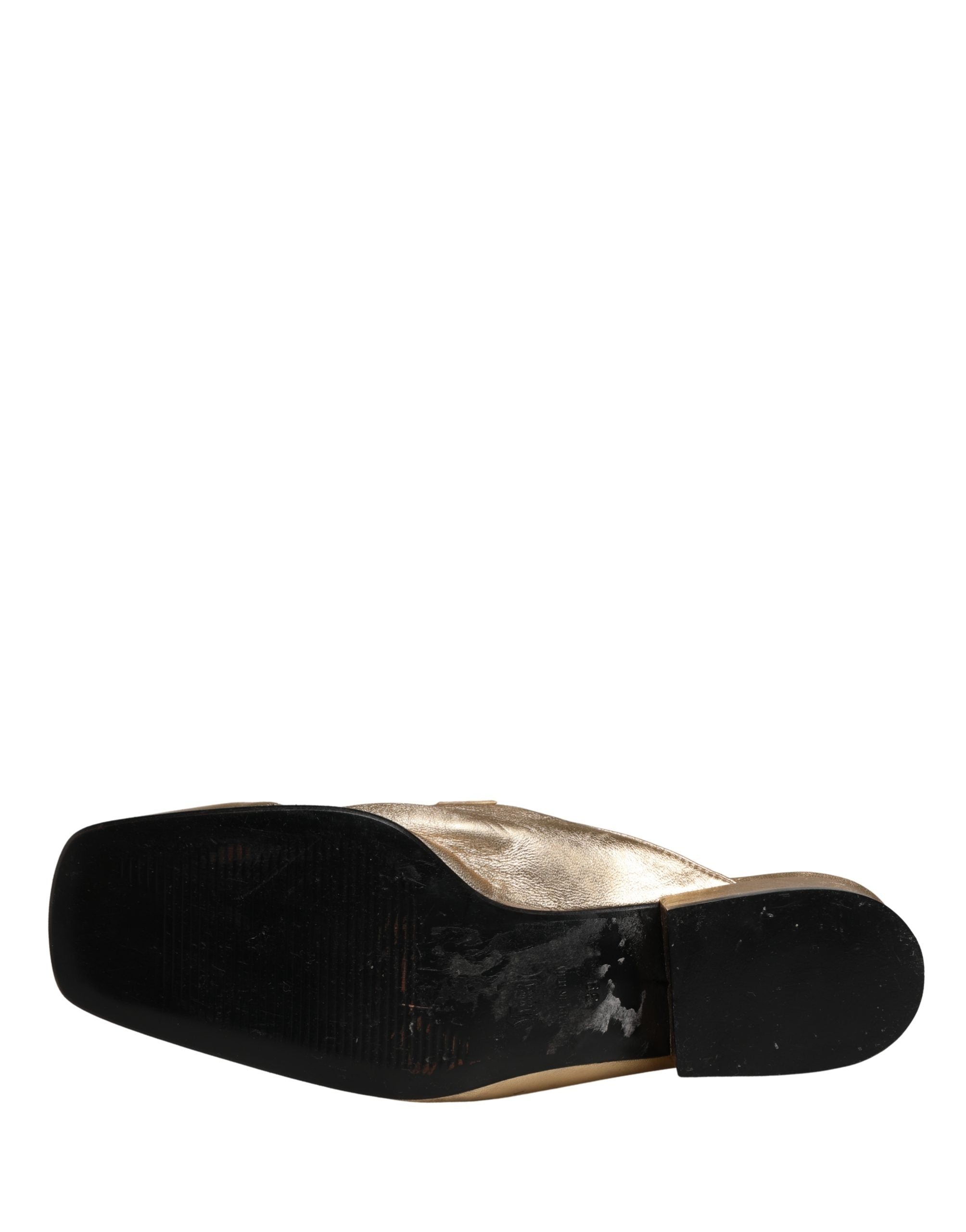 Experience unparalleled elegance with Dolce & Gabbana's gold leather flats, a testament to Italian craftsmanship that elevates every occasion with luxurious allure.