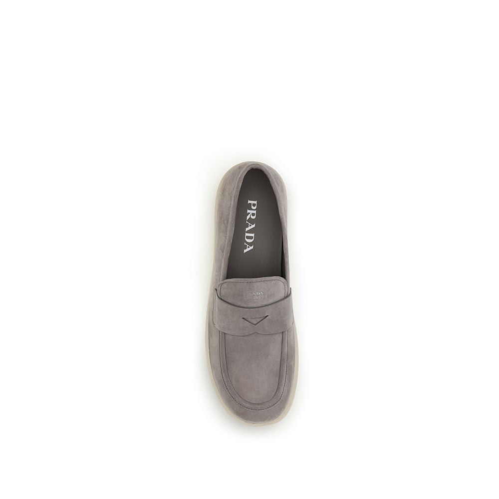 Experience the epitome of sophistication with Prada Gray Calf Leather Bos Taurus Slip-On Loafers, where exquisite craftsmanship meets timeless elegance for the discerning individual.