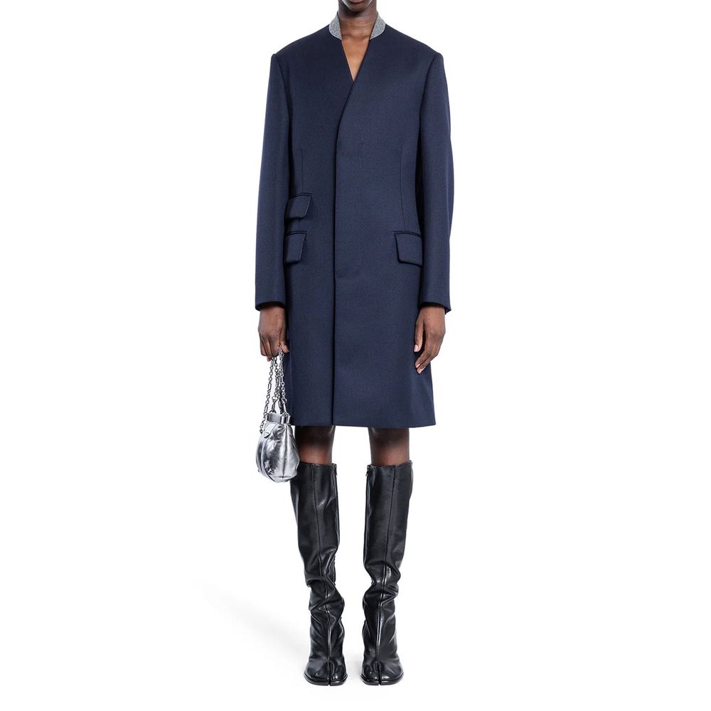 Indulge in the Maison Margiela Blue Wool Coat, a masterpiece of Italian craftsmanship in 100% wool, embodying timeless elegance and luxurious warmth for the discerning individual.