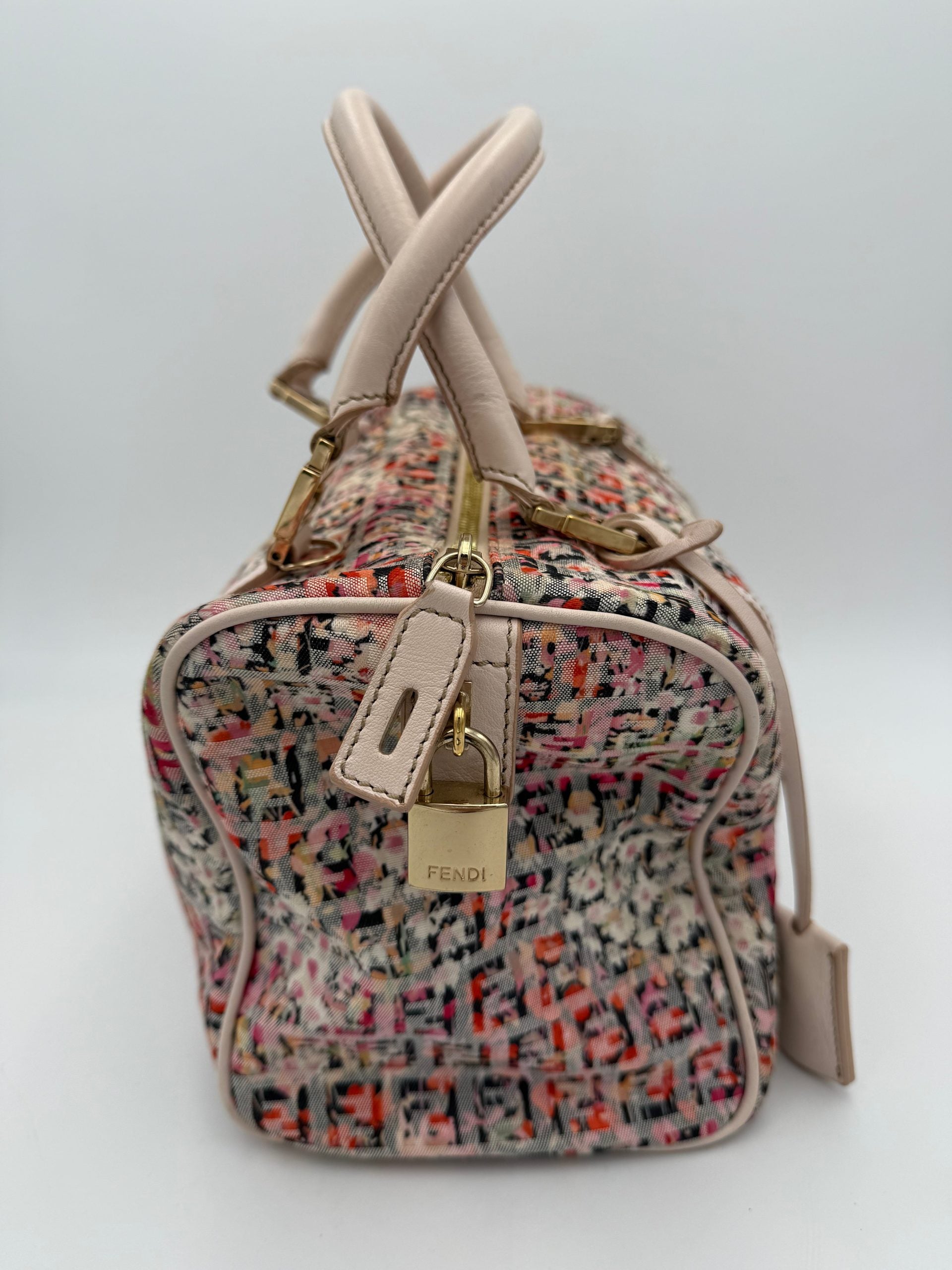 Indulge in the Fendi FENDI FF Canvas Fiori Handbag, a masterpiece of floral elegance and Italian craftsmanship, perfect for elevating your summer sophistication.