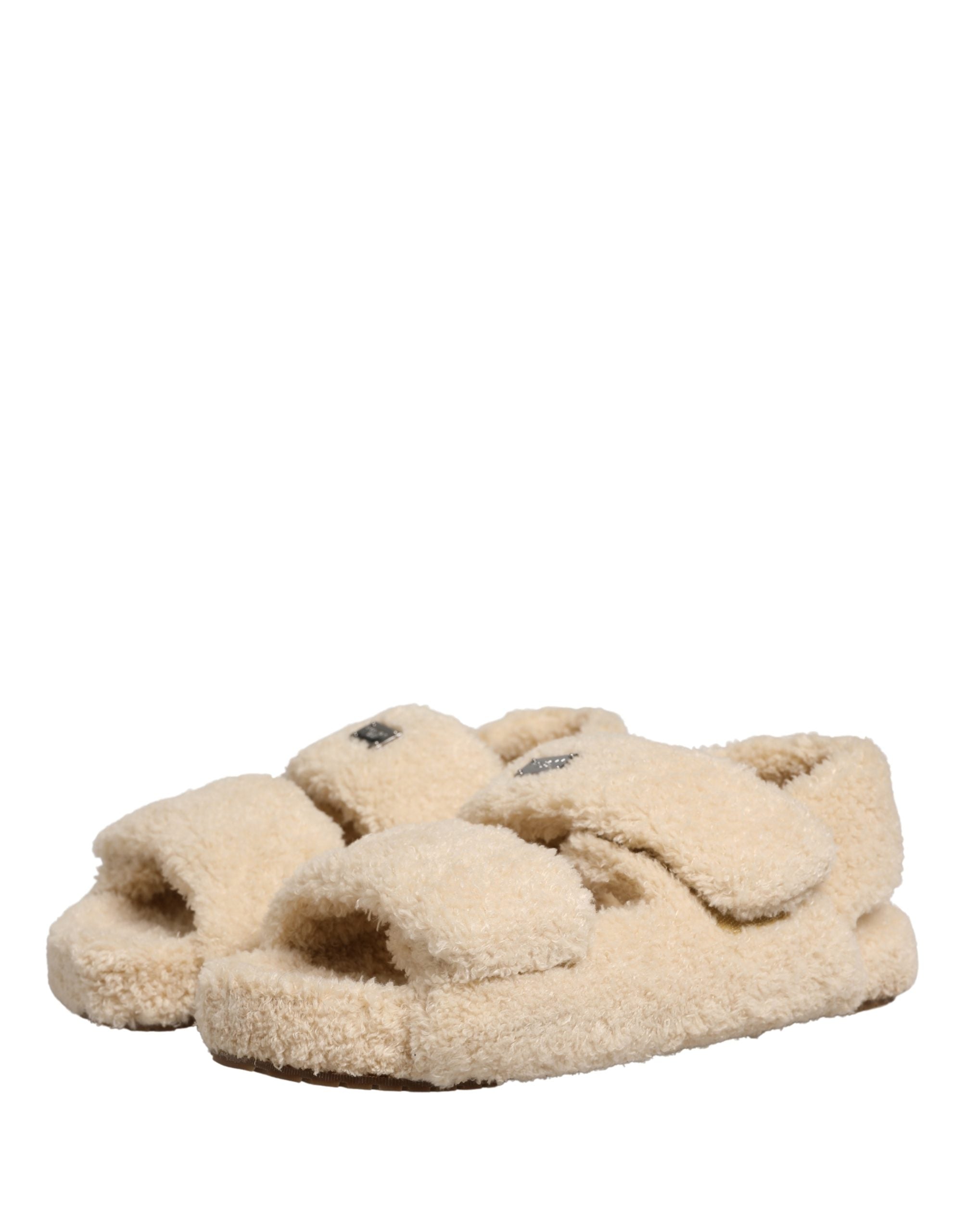 Elevate your style with Dolce & Gabbana's exquisite beige faux fur slides, where sumptuous comfort meets high-fashion elegance, perfect for any discerning wardrobe.