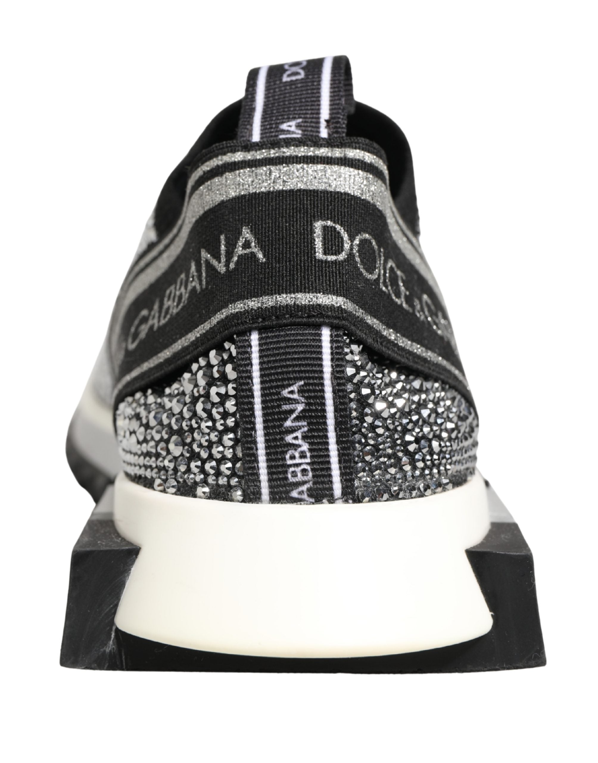 Elevate your style with Dolce & Gabbana's Silver Crystal Logo Slip On Sorrento Sneakers, a masterpiece of Italian craftsmanship blending luxury and comfort for the discerning individual.