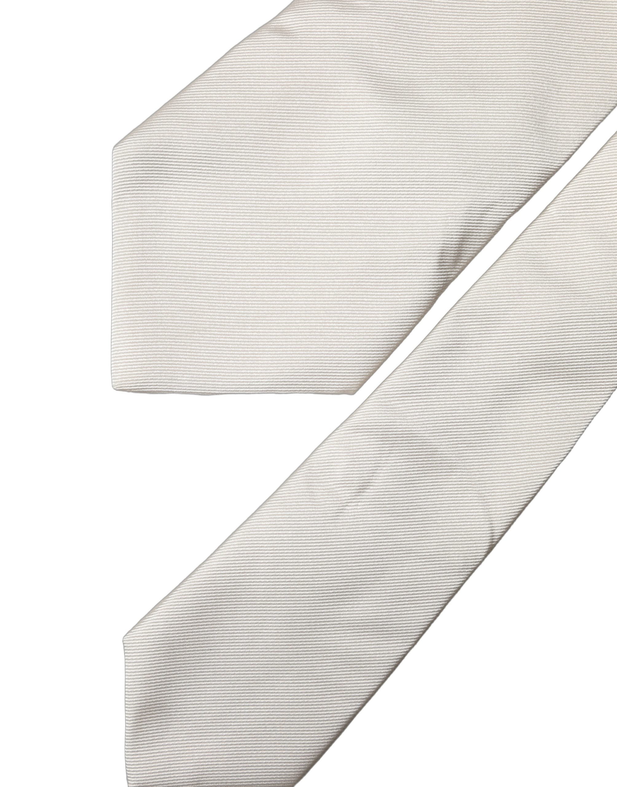 Elevate your style with the Dolce & Gabbana Off White Solid Silk Adjustable Necktie, a symbol of Italian elegance and luxurious craftsmanship for the discerning individual.