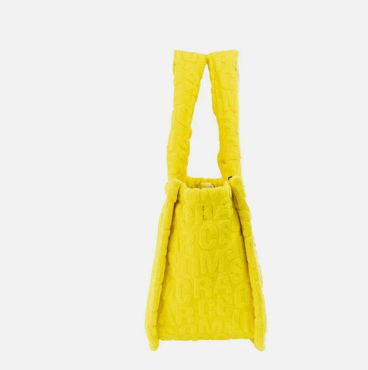 Elevate your style with the Marc Jacobs The Monogram Terry Tote in vibrant golden kiwi, a luxurious blend of contemporary design and exquisite craftsmanship for the discerning individual.