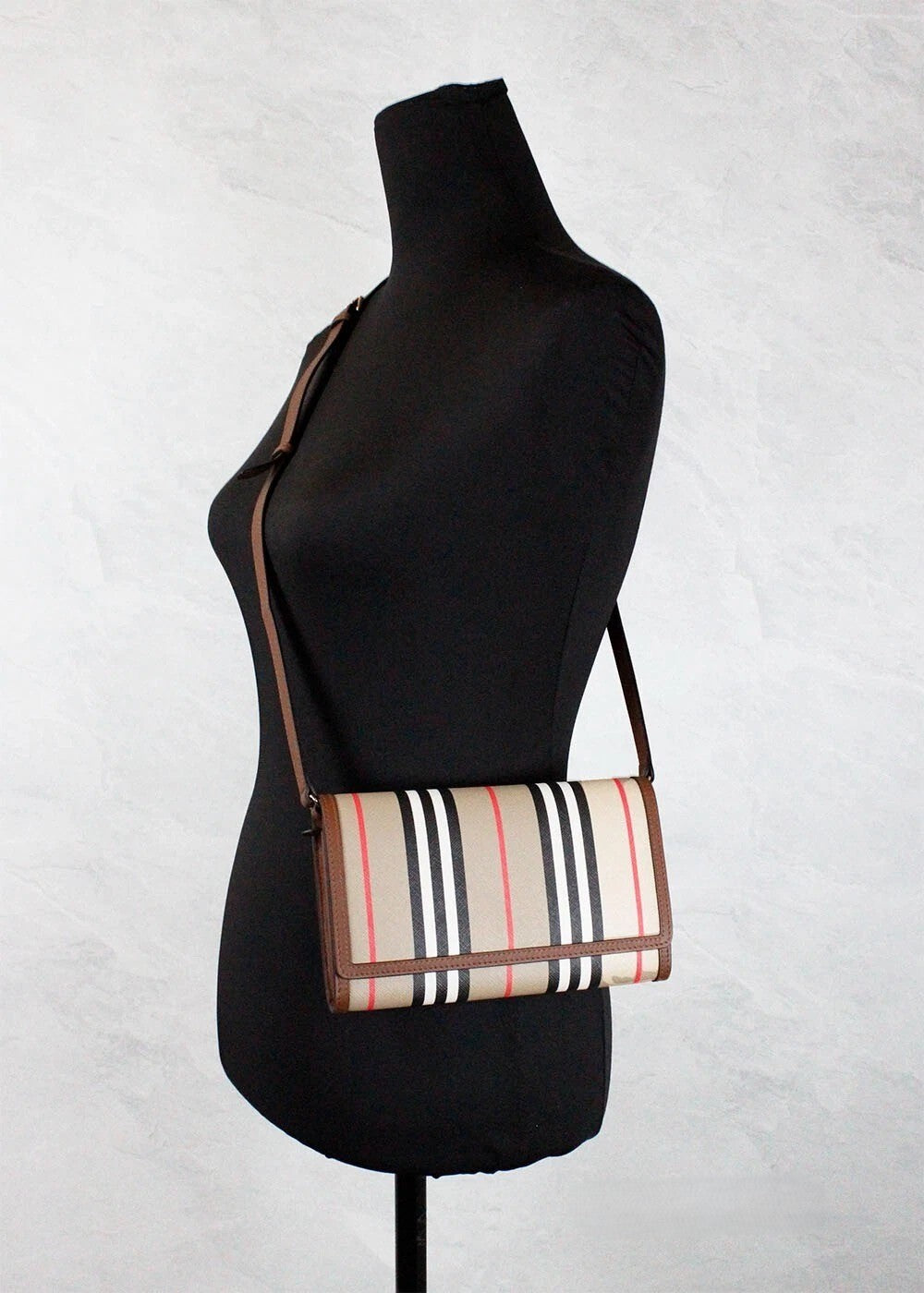 Indulge in the exquisite Burberry Hannah Icon Stripe Archive Tan E-Canvas Leather Wallet Crossbody Bag, a blend of luxury and practicality for the discerning individual.