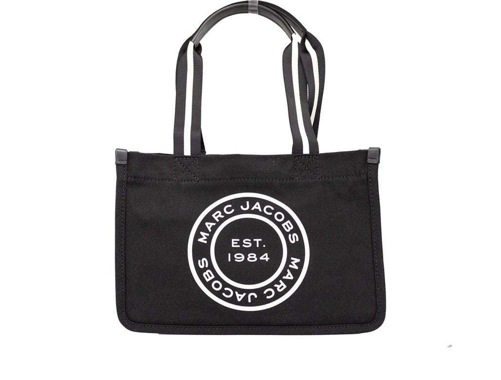 Indulge in the sophistication of the Marc Jacobs Medium Black Canvas Tote, where exquisite craftsmanship meets timeless elegance, perfect for any discerning occasion.