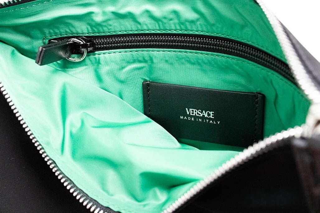 Discover the Versace Large Black Nylon Fabric Medusa Convertible Pouch, a masterpiece of elegance and versatility, perfect for the discerning individual seeking sophistication.
