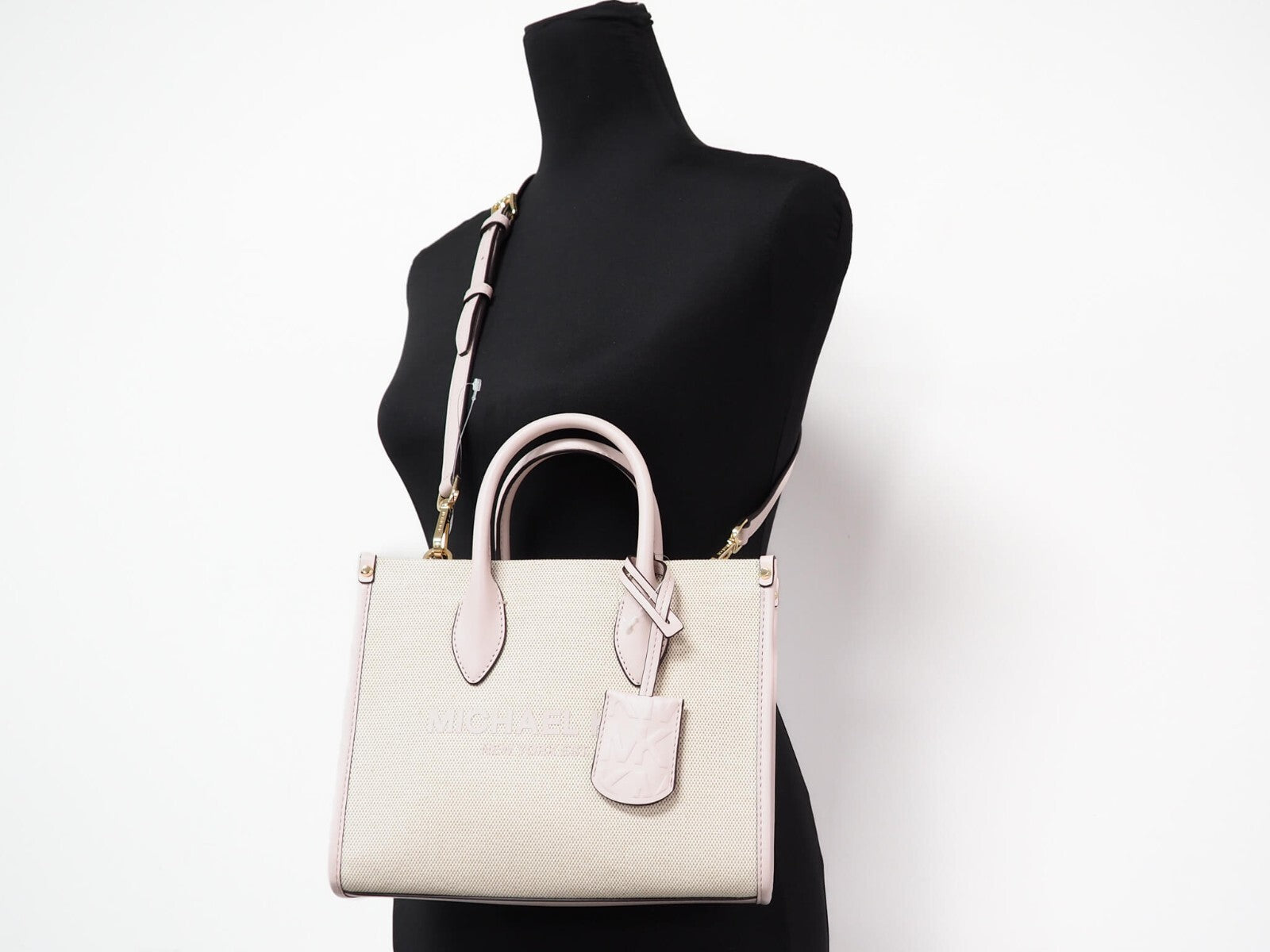 Elevate your style with the Michael Kors Mirella Small Powder Blush Canvas Shopper, a blend of exquisite craftsmanship and timeless elegance, perfect for any occasion.