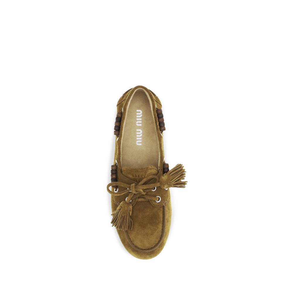Experience the allure of Miu Miu's Beige Calf Leather Bos Taurus Slip-On Loafers, where exquisite craftsmanship meets timeless elegance for the discerning individual.