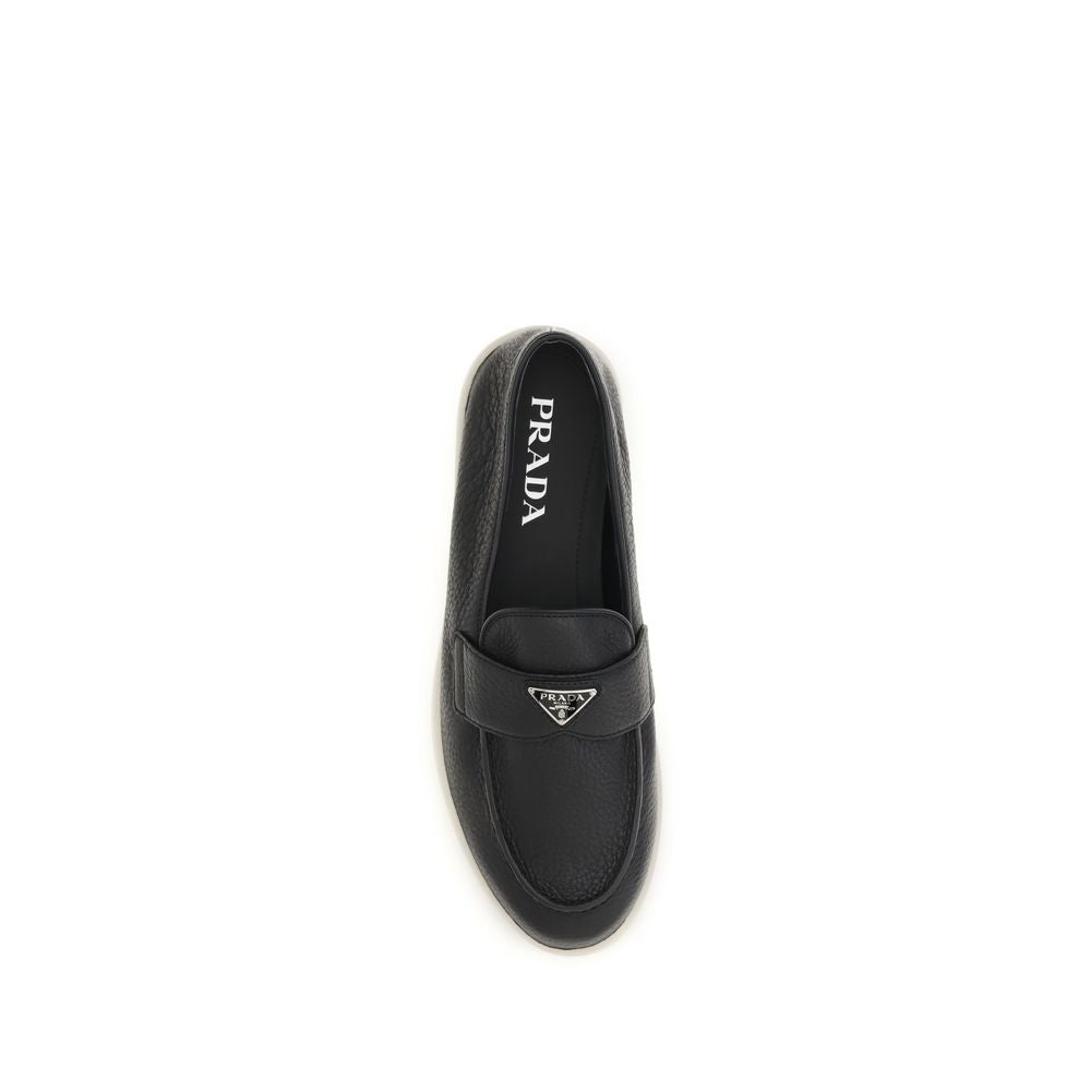 Indulge in the exquisite Prada Black Calf Leather Bos Taurus Slip-On Loafers, where Italian craftsmanship meets timeless elegance, perfect for the discerning individual.