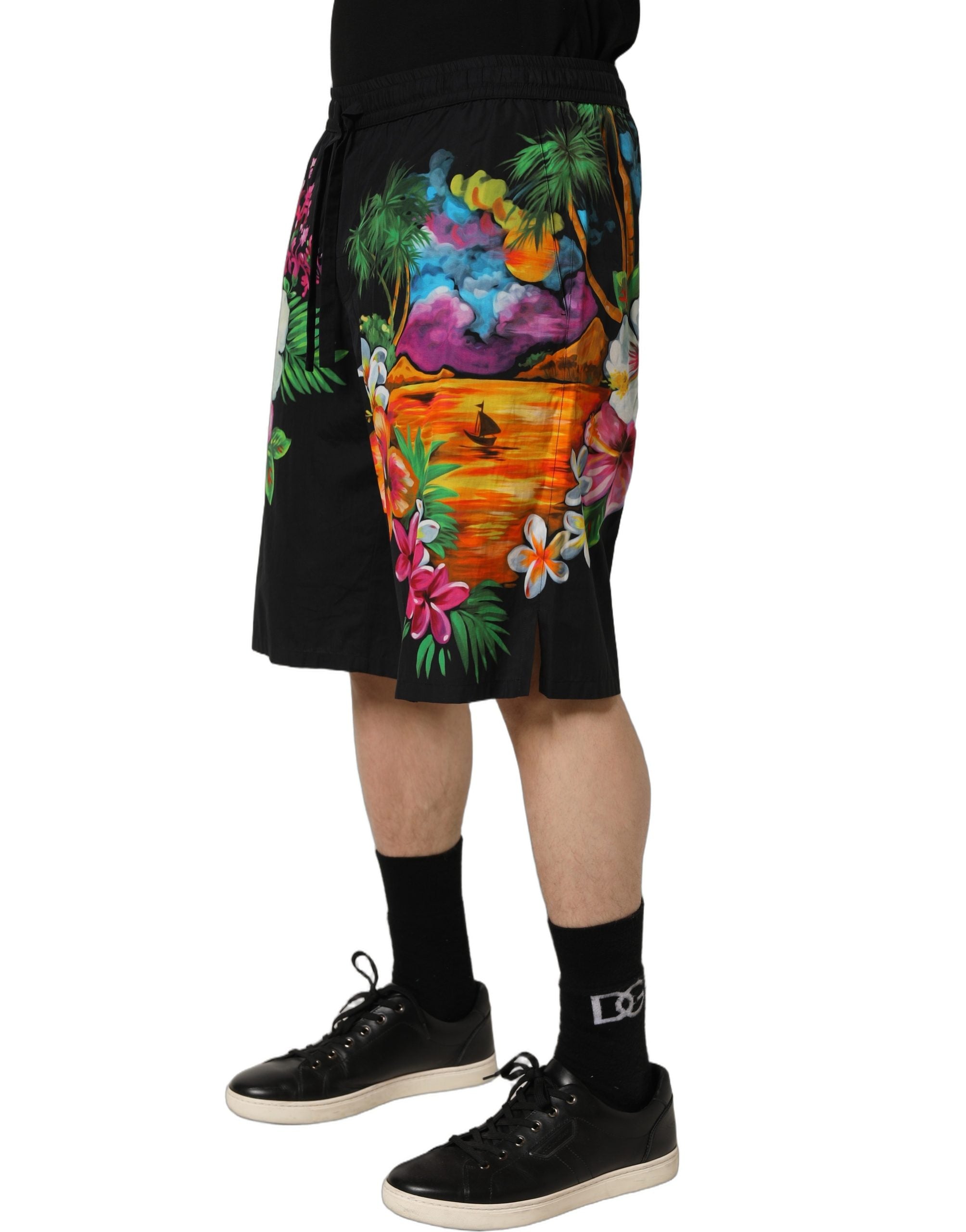 Elevate your summer wardrobe with Dolce & Gabbana's Black Cotton Tropical Floral Bermuda Shorts, where exquisite craftsmanship meets vibrant elegance for timeless allure.