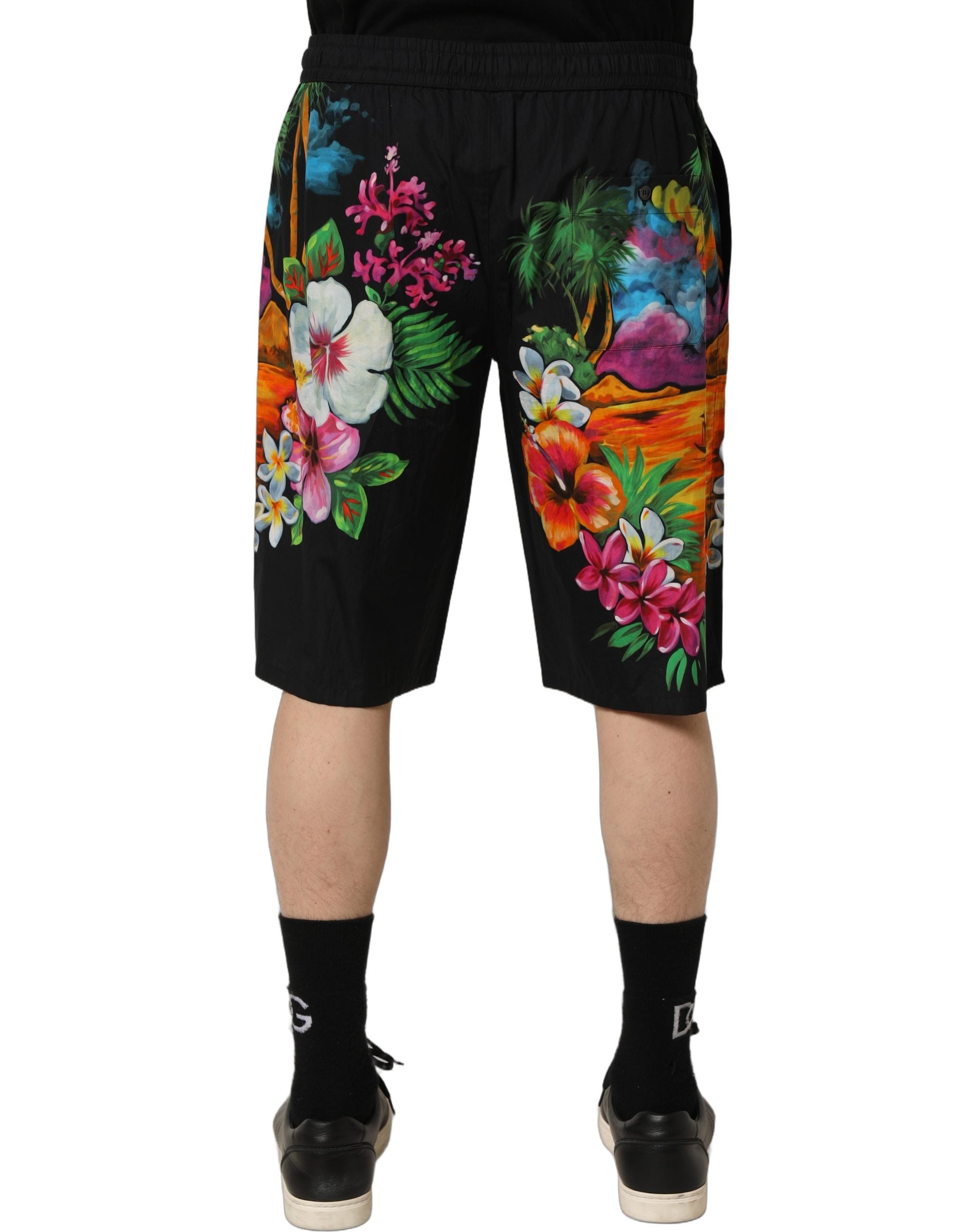 Elevate your summer wardrobe with Dolce & Gabbana's Black Cotton Tropical Floral Bermuda Shorts, where exquisite craftsmanship meets vibrant elegance for timeless allure.