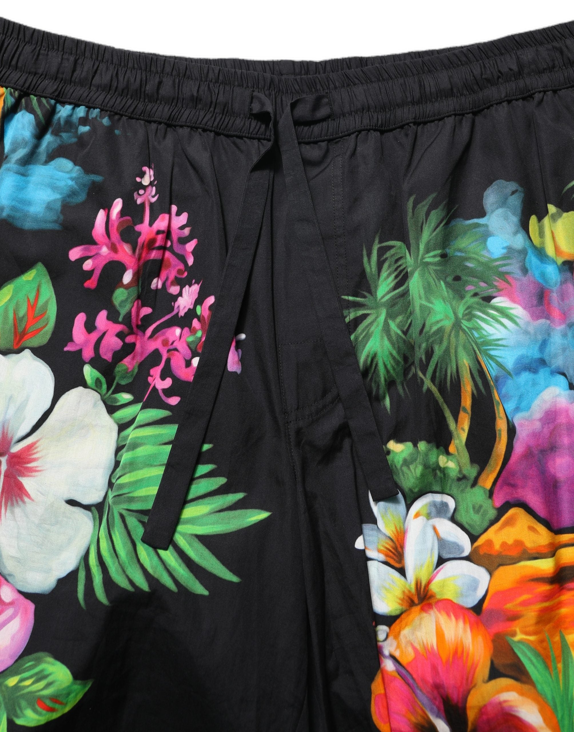 Indulge in the elegance of Dolce & Gabbana's Black Cotton Tropical Floral Bermuda Shorts, where luxurious craftsmanship meets vibrant design for timeless sophistication.