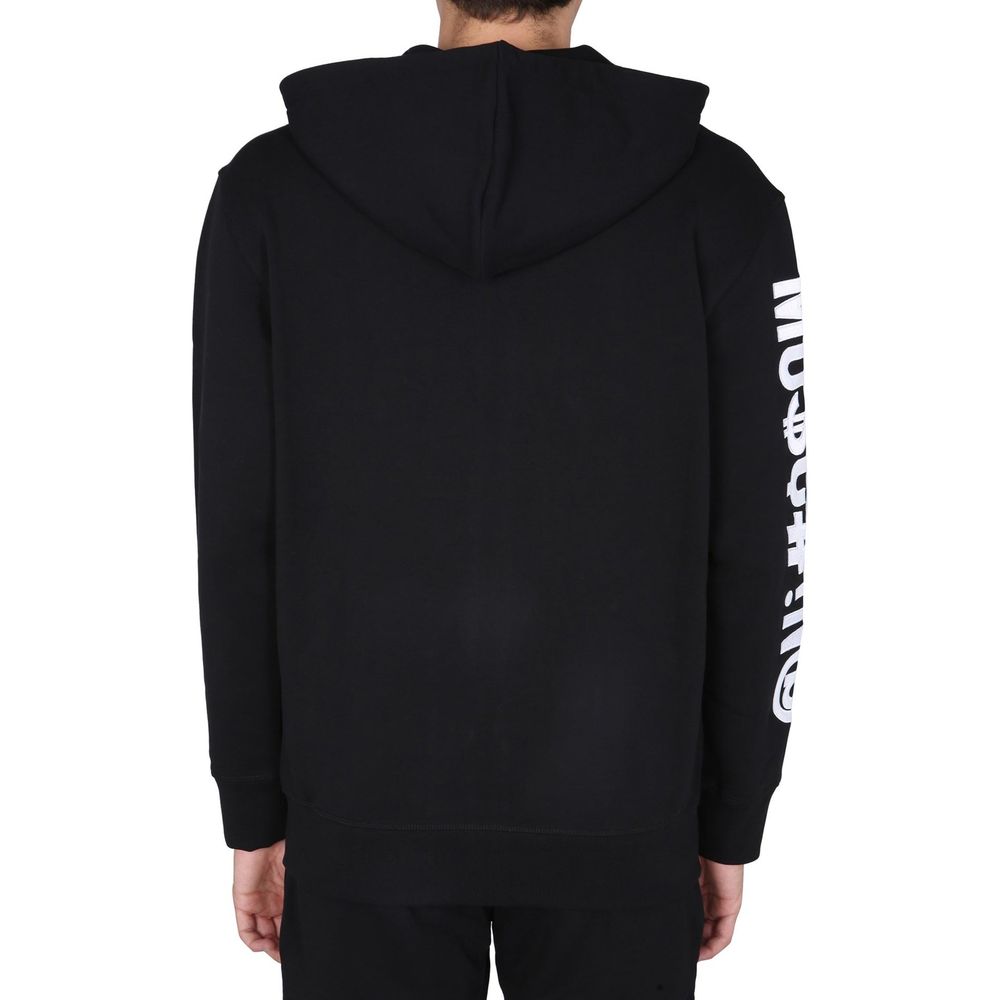Indulge in the Moschino Couture Black Cotton Sweatshirt, a masterpiece of Italian craftsmanship, merging luxurious comfort with sophisticated style for the discerning individual.