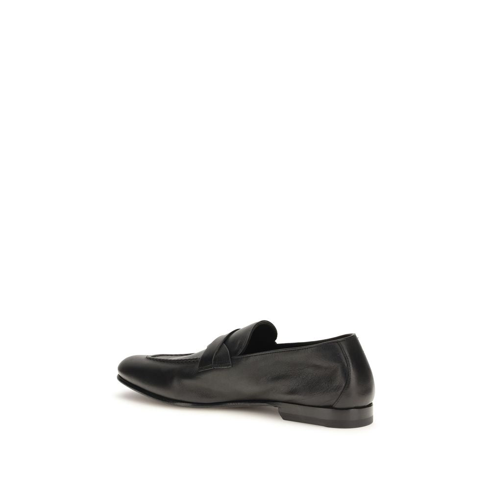 Experience the artisanal elegance of Tom Ford Black Calf Leather Bos Taurus Slip-On Loafers, where luxurious craftsmanship meets timeless sophistication for the discerning individual.