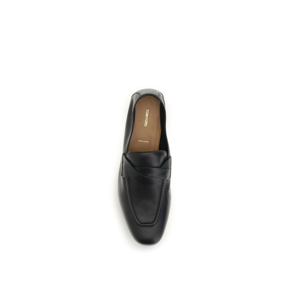 Experience the exquisite craftsmanship of Tom Ford's Black Calf Leather Bos Taurus Slip-On Loafers, a timeless fusion of luxury and sophistication for the discerning individual.