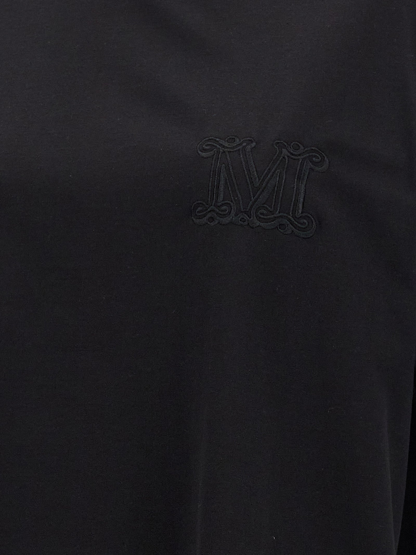 Indulge in the Max Mara Black Cotton T-Shirt, a luxurious staple crafted from premium cotton, embodying sophistication and timeless elegance for the discerning fashionista.