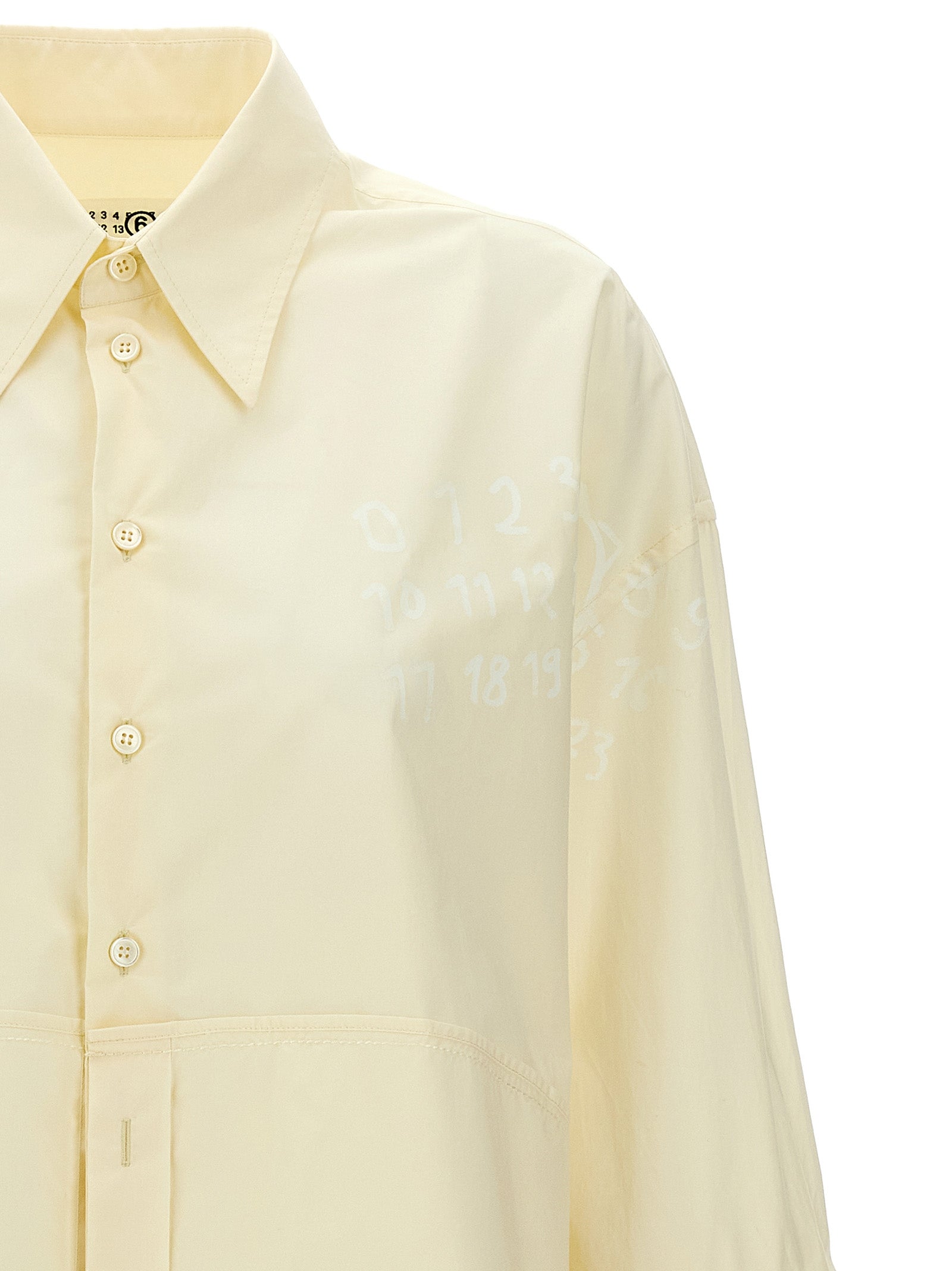 Discover the MM6 Maison Margiela White Cotton Blouse, a luxurious statement piece that embodies avant-garde elegance and exquisite Italian craftsmanship for the discerning fashion lover.
