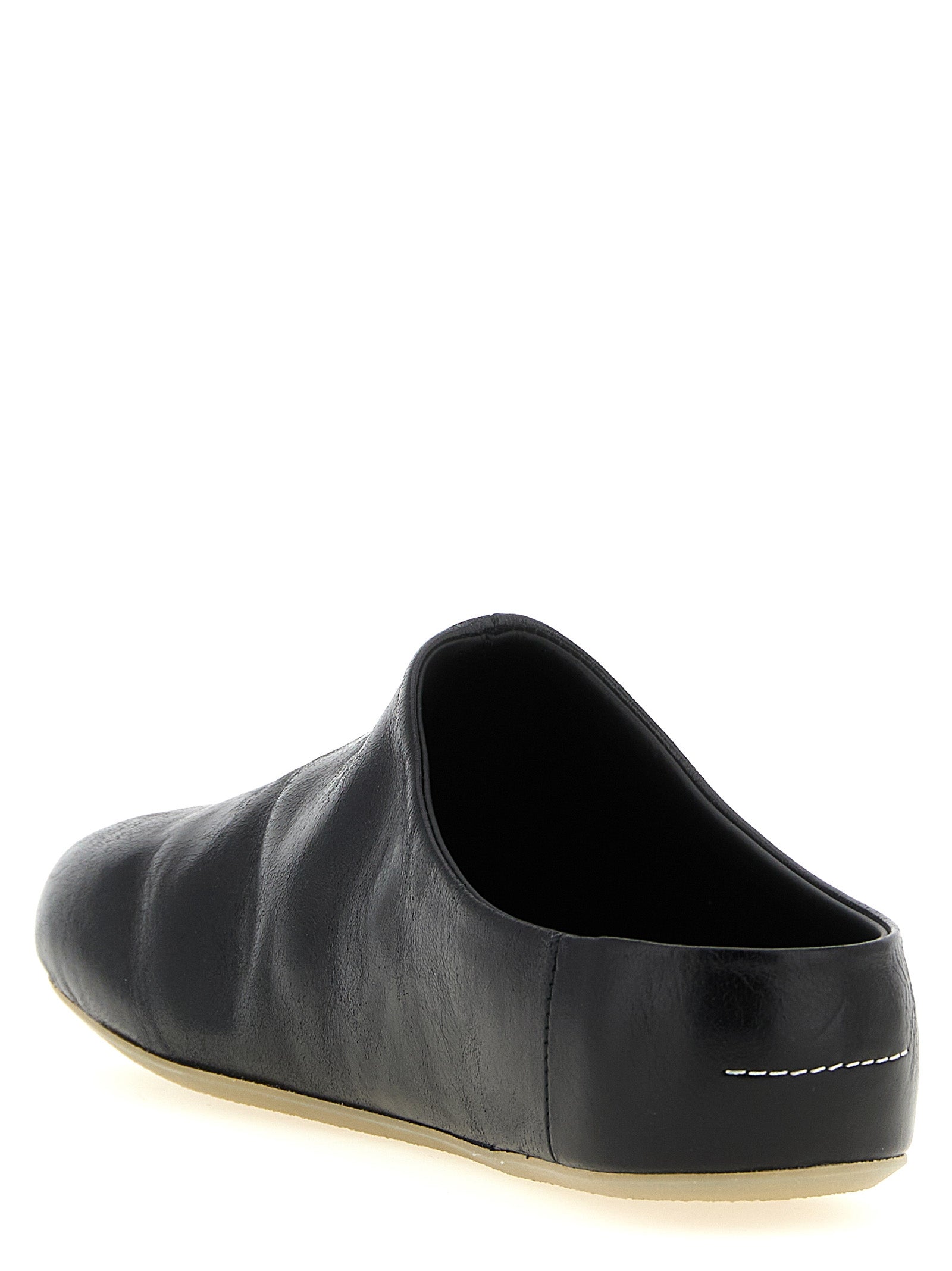 Experience the allure of MM6 Maison Margiela's Black Calfskin Clogs, where artisanal luxury meets avant-garde design, perfect for the discerning fashion connoisseur.