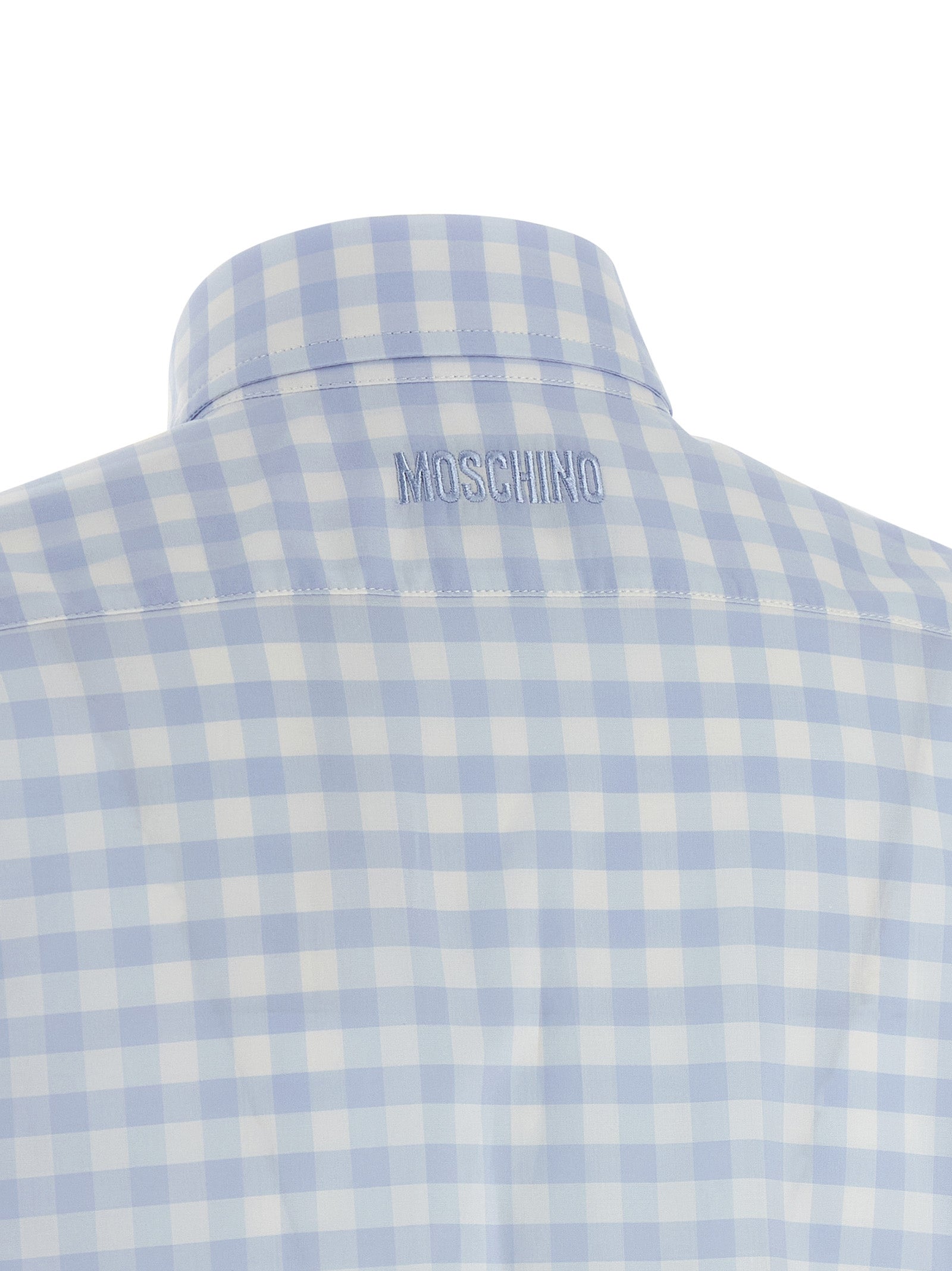 Discover the Moschino Blue Cotton Blouse, a masterpiece of artisanal elegance, featuring a delicate micro vichy pattern and heart patch, perfect for the discerning fashion connoisseur.