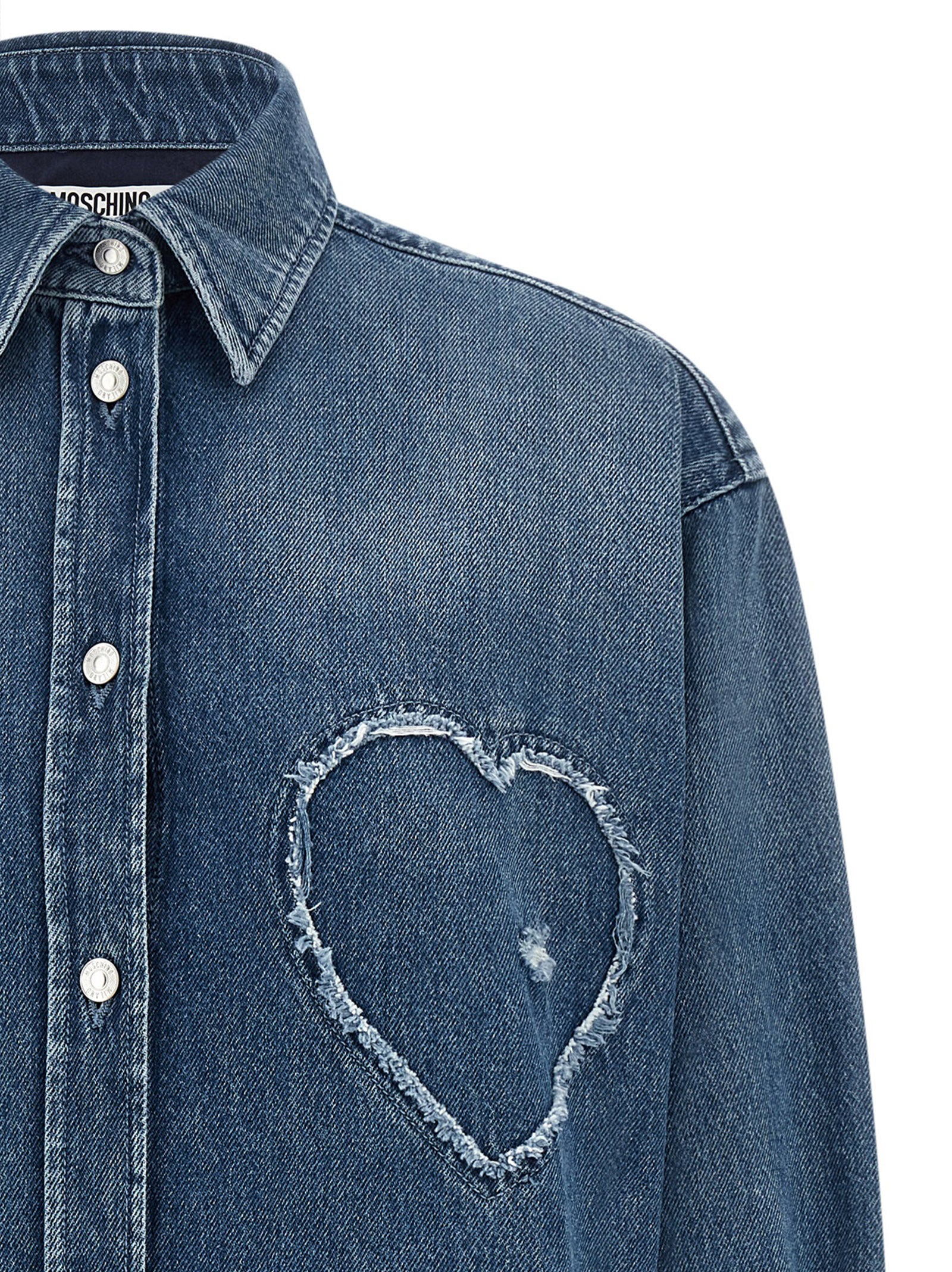 Discover the Moschino Blue Cotton Blouse, a luxurious expression of artisanal elegance, featuring unique heart detailing and exquisite craftsmanship for the discerning individual.