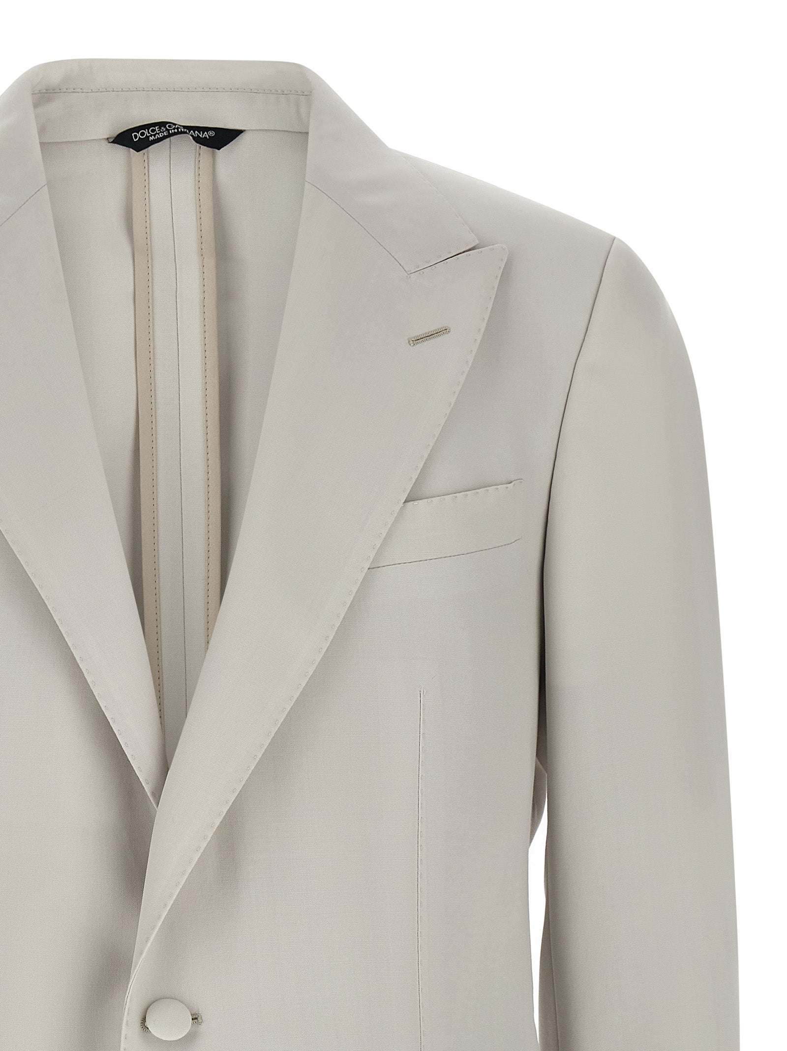 Elevate your wardrobe with the Dolce & Gabbana Gray Virgin Wool Blazer, a masterpiece of Italian craftsmanship that embodies timeless elegance and sophisticated allure.