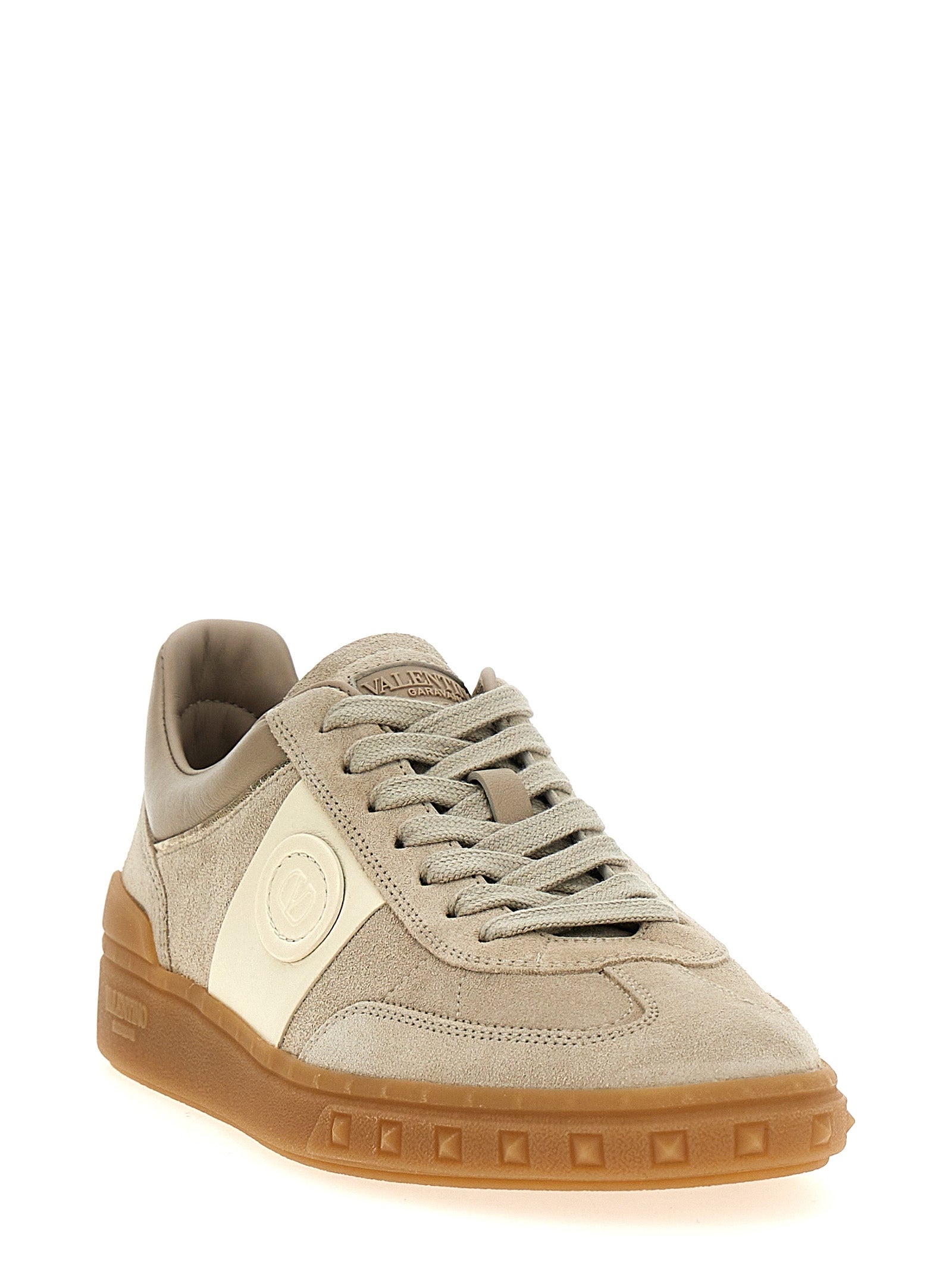 Indulge in the elegance of Valentino Garavani's Beige Calfskin Low Top Sneakers, where exquisite craftsmanship meets luxurious design for a timeless statement.