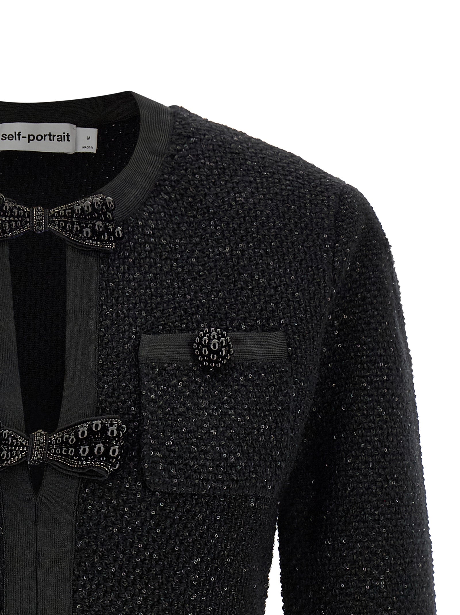 Indulge in the exquisite allure of the Self-Portrait Black Sequin Knit Mini Dress, where luxurious materials and intricate details redefine modern elegance for every occasion.