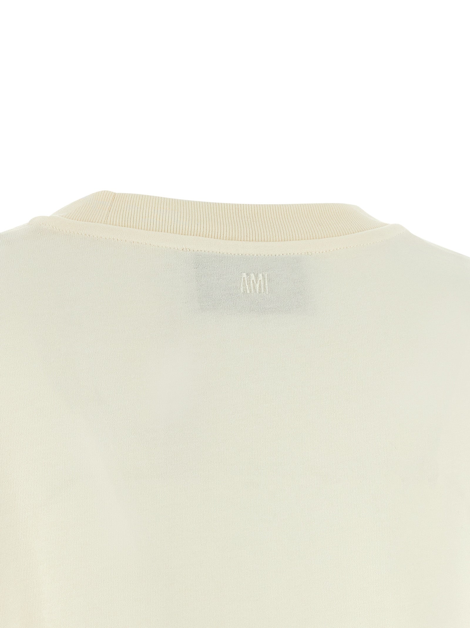 Indulge in the Ami Paris White Cotton T-Shirt, a luxurious staple crafted from 100% cotton, embodying contemporary elegance and effortless sophistication for discerning tastes.