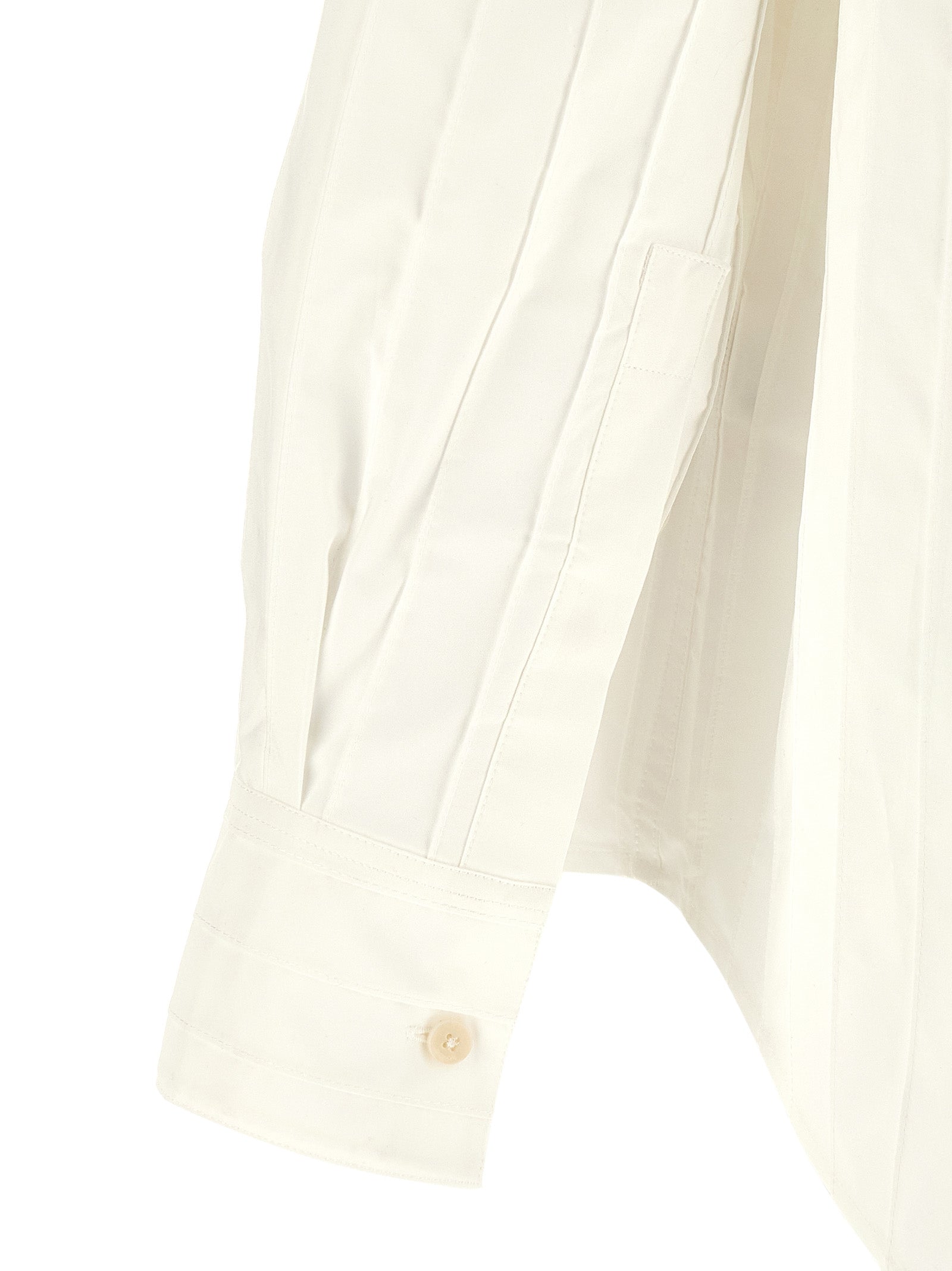 Elevate your wardrobe with the Jacquemus White Cotton Blouse, a masterpiece of embroidered cotton poplin, embodying timeless elegance and sophisticated allure.
