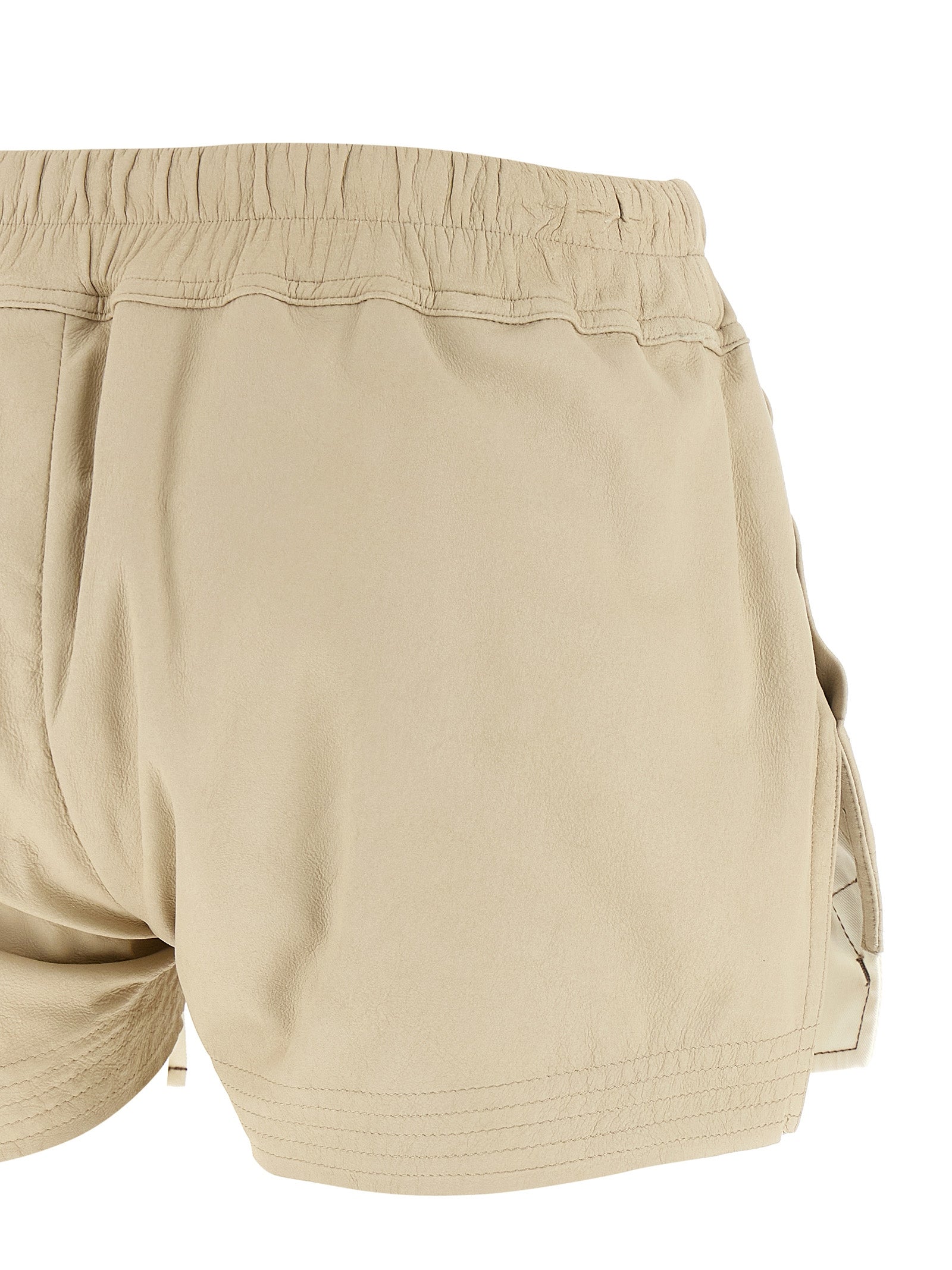 Experience the allure of Rick Owens' Beige Lamb Leather Bermuda Shorts, a luxurious embodiment of avant-garde craftsmanship and timeless elegance for the discerning fashionista.