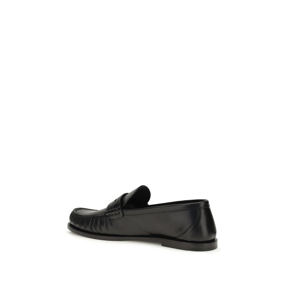 Elevate your style with Saint Laurent's Black Calf Leather Bos Taurus Slip-On Loafers, a masterpiece of artisanal craftsmanship and timeless elegance, perfect for the discerning individual.