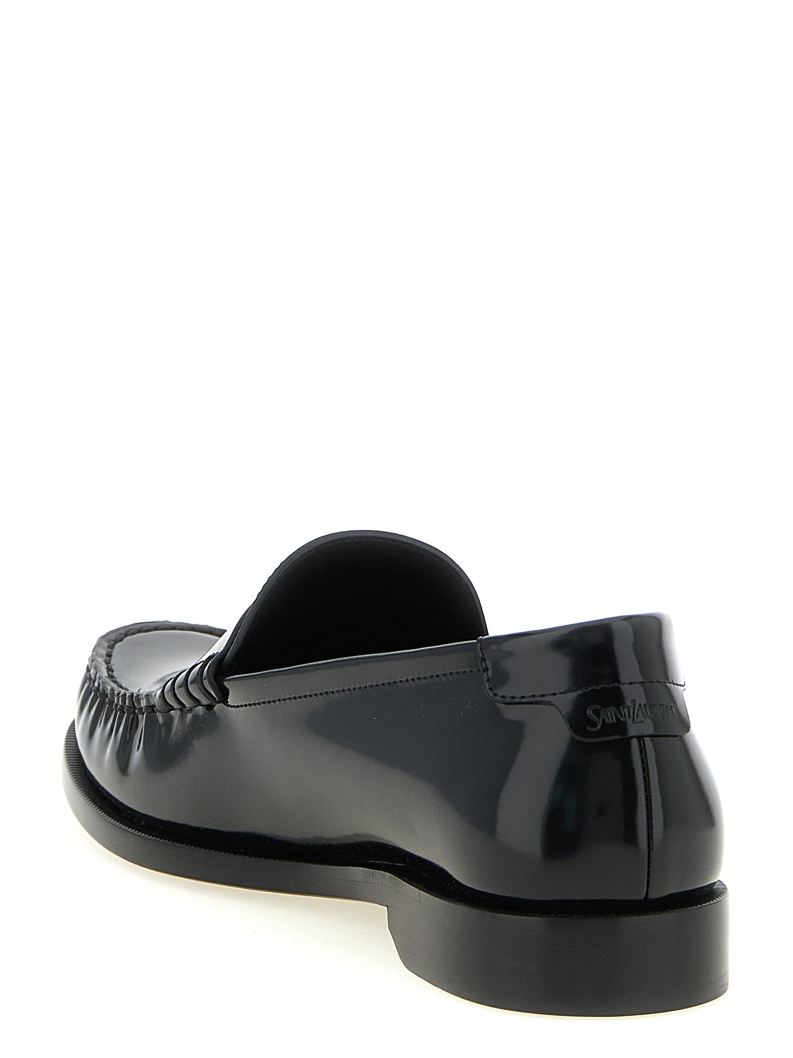 Experience the allure of Saint Laurent's Black Calfskin Slip-On Loafers, crafted in Italy from luxurious leather, embodying sophistication and timeless elegance for the discerning individual.