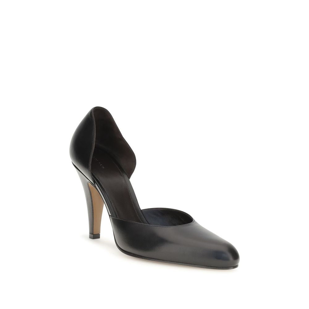 Elevate your style with The Row Black Lamb Ovis Aries Aries High Heel Pumps, a masterpiece of refined craftsmanship and timeless elegance for the discerning individual.