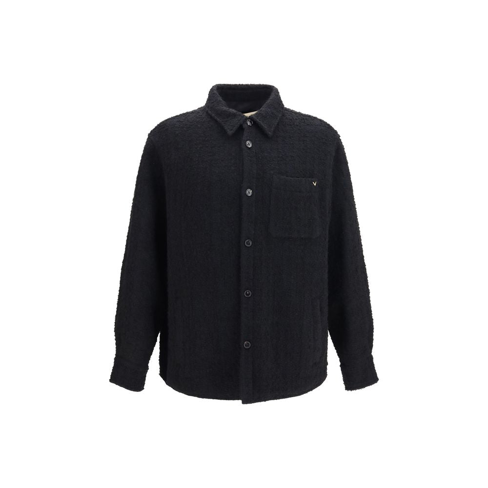 Elevate your style with the Valentino Garavani Black Cotton Full-Length Jacket, a masterpiece of textured luxury, blending sophistication and comfort for the discerning individual.