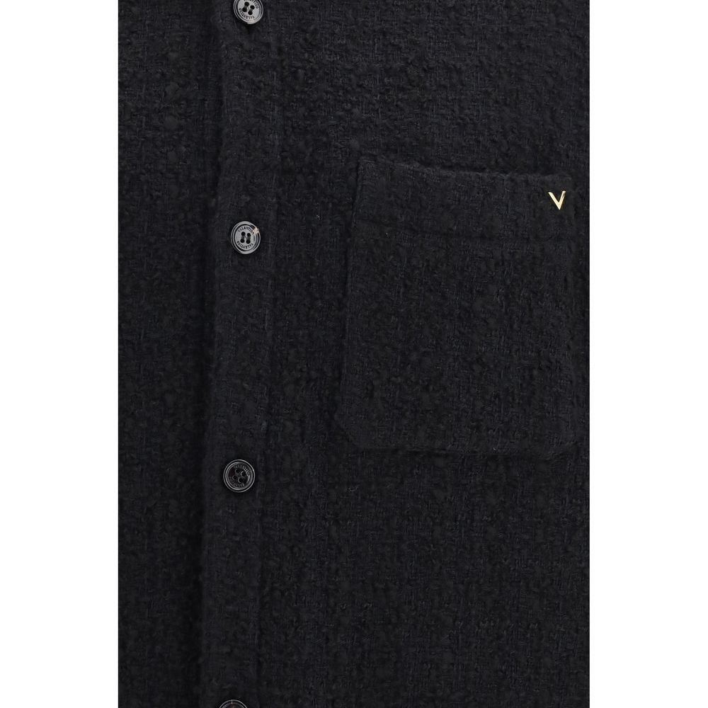 Discover the Valentino Garavani Black Cotton Full-Length Jacket, a masterpiece of textured elegance, crafted from a luxurious blend for the discerning individual.