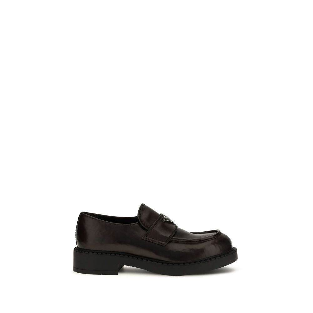 Elevate your wardrobe with Prada's Brown Calf Leather Bos Taurus Slip-On Loafers, a masterclass in luxurious craftsmanship and timeless elegance, perfect for any occasion.