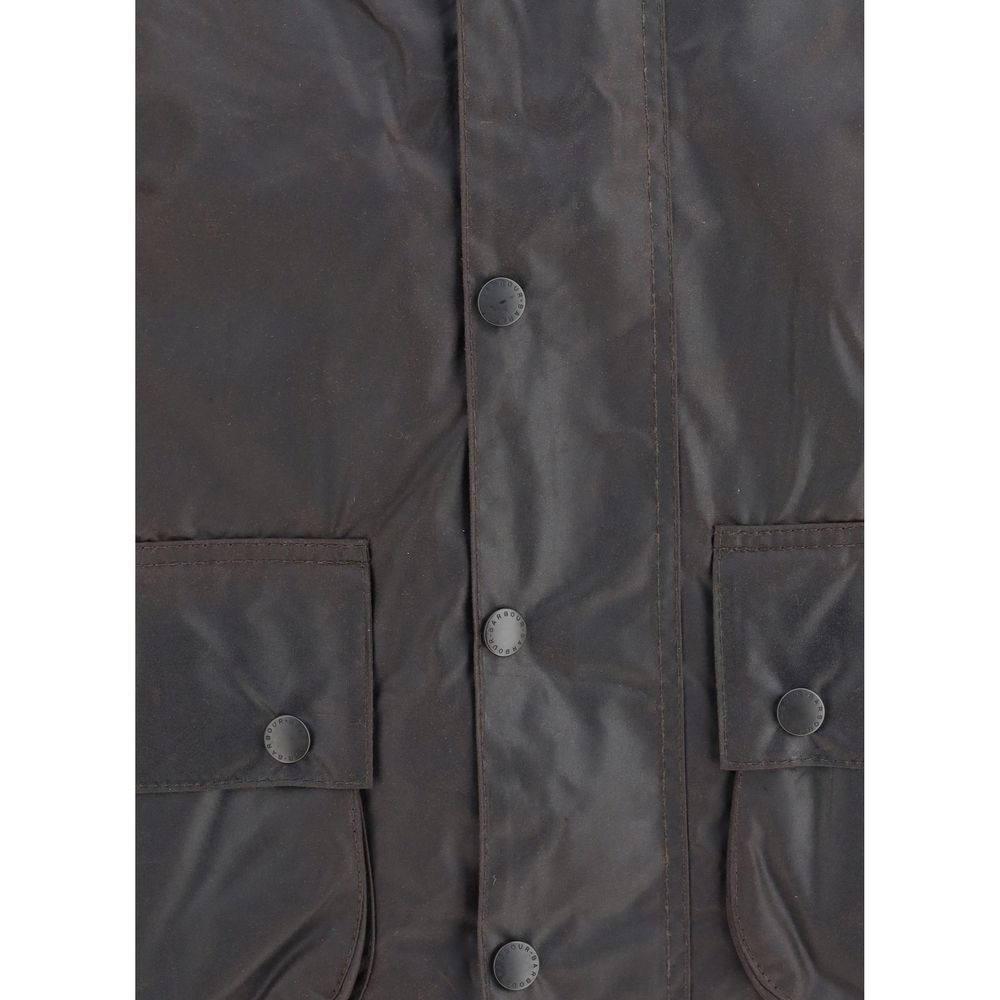 Elevate your wardrobe with the Barbour Black Cotton Coat, a masterpiece of Thornproof waxed cotton, merging timeless elegance with unparalleled functionality for the discerning individual.