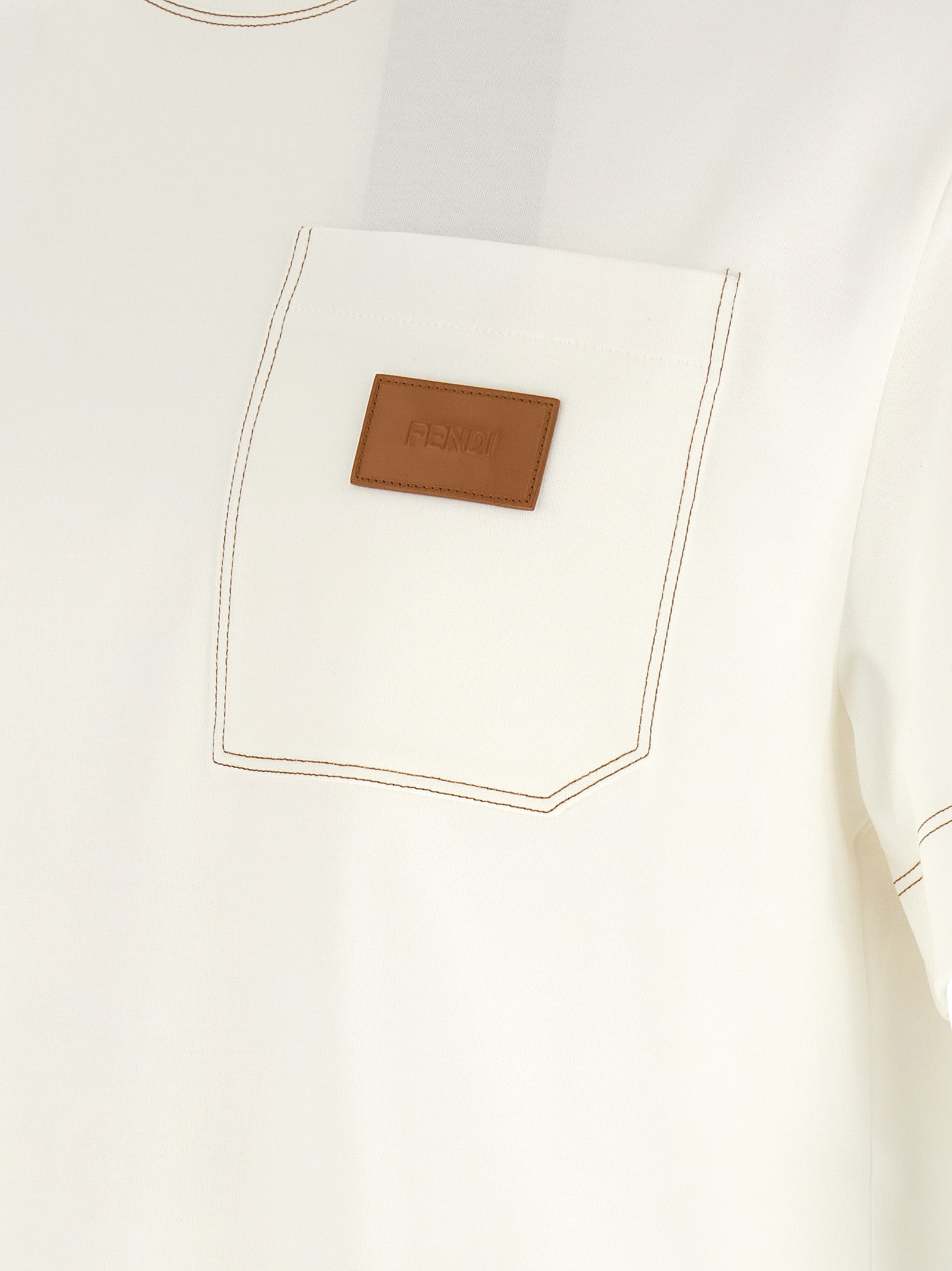 Experience the exquisite allure of Fendi's White Cotton T-Shirt, a masterpiece of Italian craftsmanship that elevates your wardrobe with timeless elegance and sophistication.